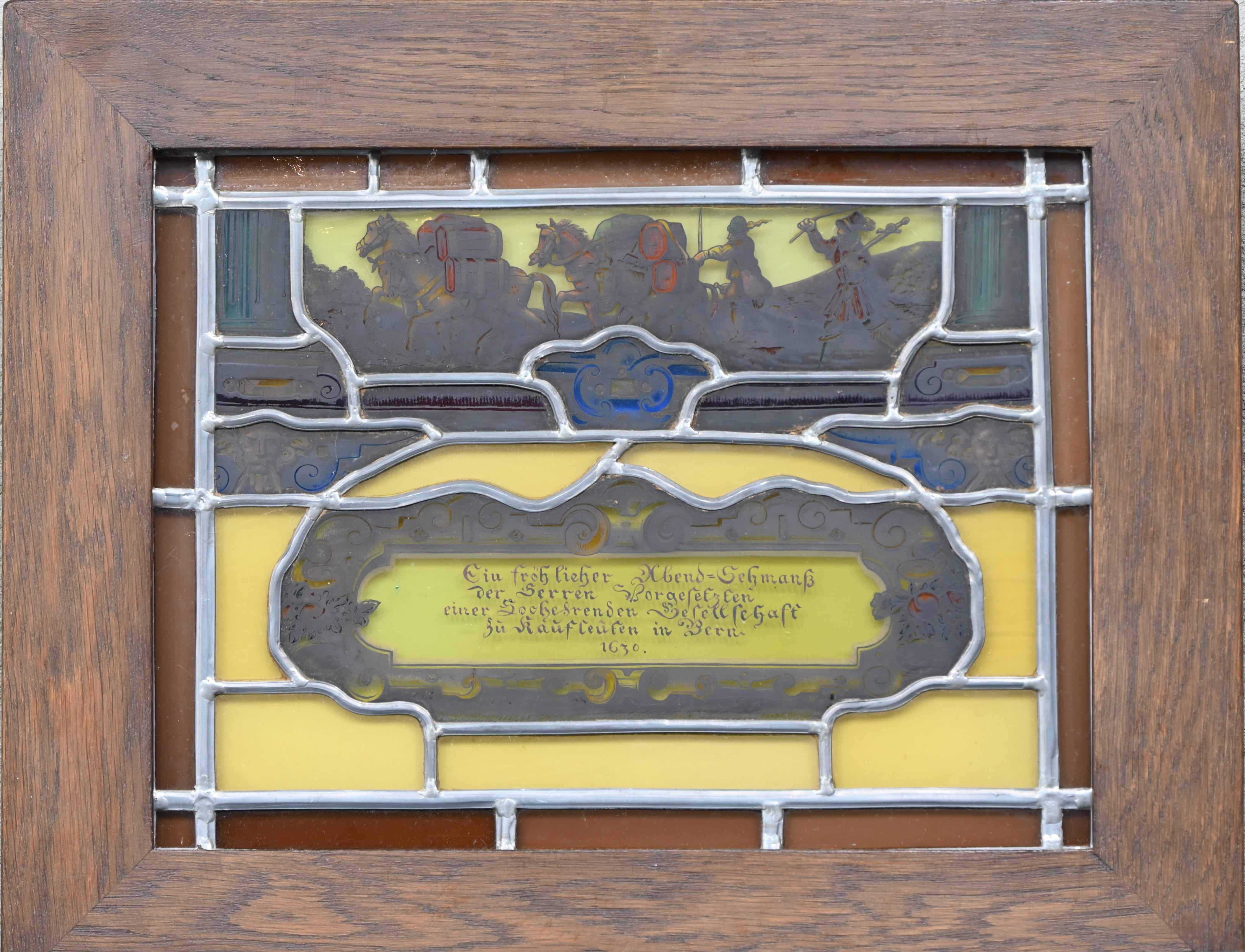 “Ein fröhllicher Abend-Schmanss der Serren vorgesezten einer Lochesrenden Gesellschaft zu Käuflauten in Bern 1630”. Een klein glasraam gemonteerd in een lichtbak “Ein fröhllicher Abend-Schmanss der Serren vorgesezten einer Lochesrenden Gesellschaft zu Käuflauten in Bern 1630”. Een klein glasraam gemonteerd in een lichtbak.