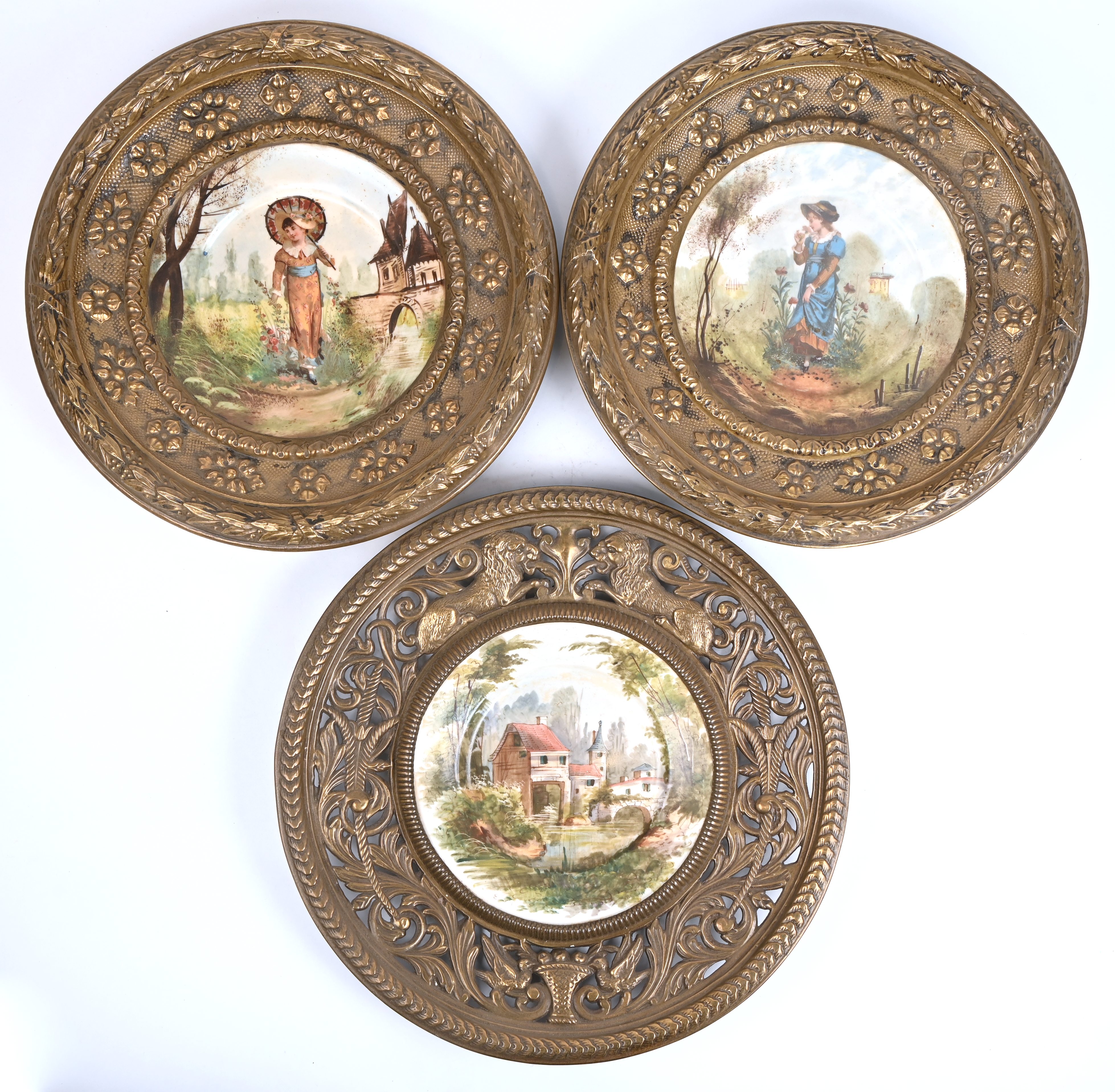 Drie porseleinen borden in ronde messing kader Drie porseleinen borden in ronde messing kader.