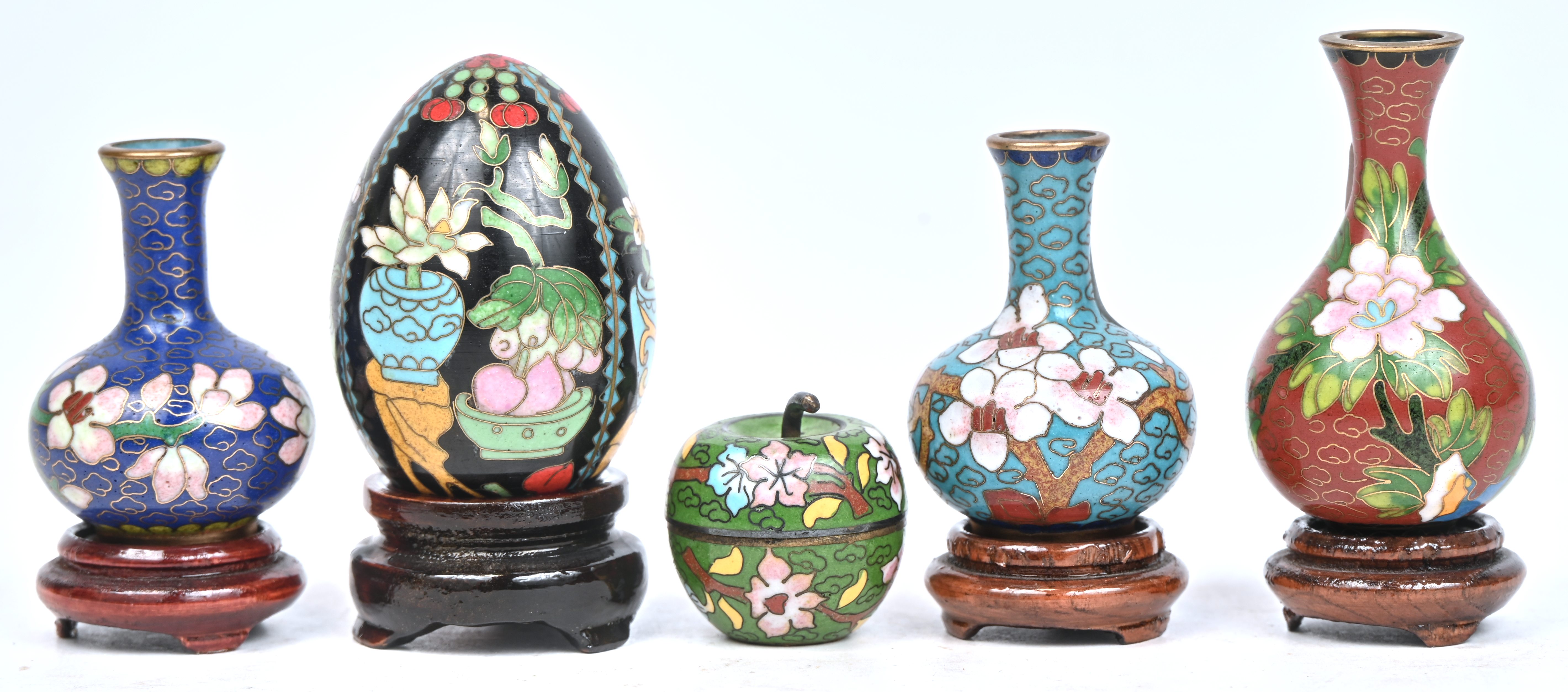 Een lot van 5 cloisonné stuks, 3 vaasjes, een doosje in de vorm van een appel, en een ei. Eén zonder sokkeltje Een lot van 5 cloisonné stuks, 3 vaasjes, een doosje in de vorm van een appel, en een ei. Eén zonder sokkeltje.