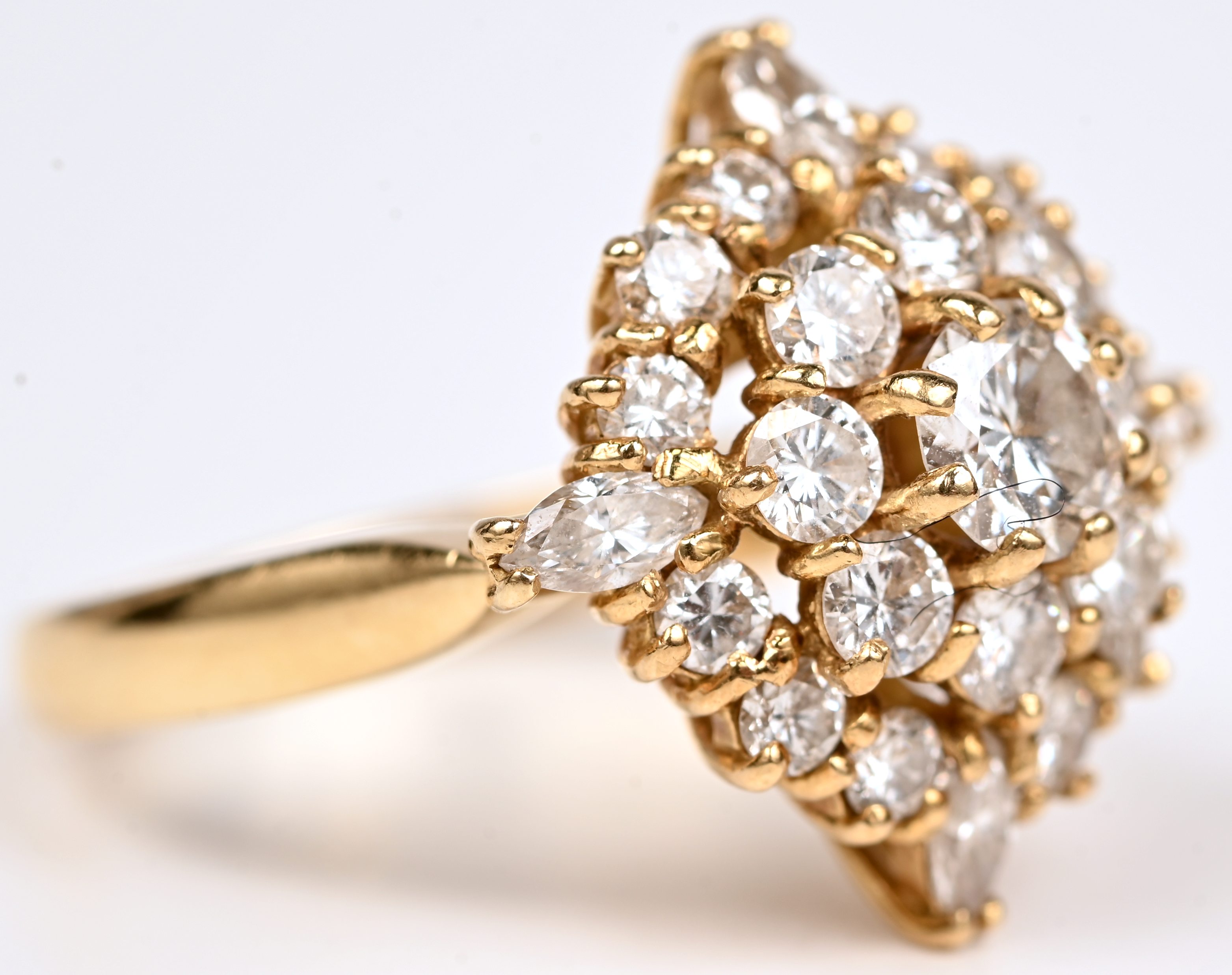 Een 18 kt geelgouden ring bezet met briljanten en vier in markies geslepen diamanten met een gezamenlijk gewicht van +- 1,40 ct Een 18 kt geelgouden ring bezet met briljanten en vier in markies geslepen diamanten met een gezamenlijk gewicht van +- 1,40 ct.