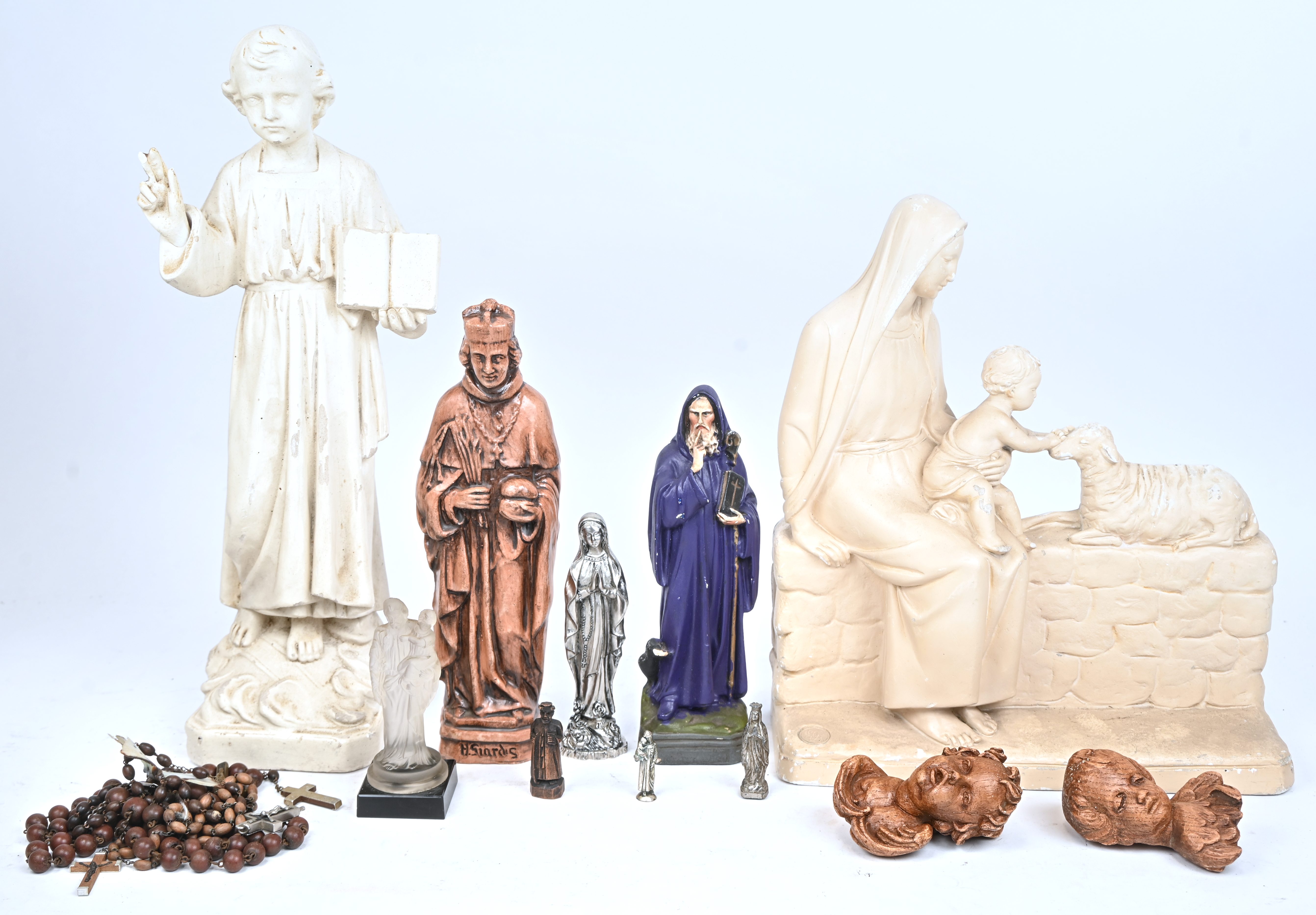 Een partij religieuze beelden van metaal, plaaster, hout en glas. Toegevoegd enkele paternosters Een partij religieuze beelden van metaal, plaaster, hout en glas. Toegevoegd enkele paternosters.