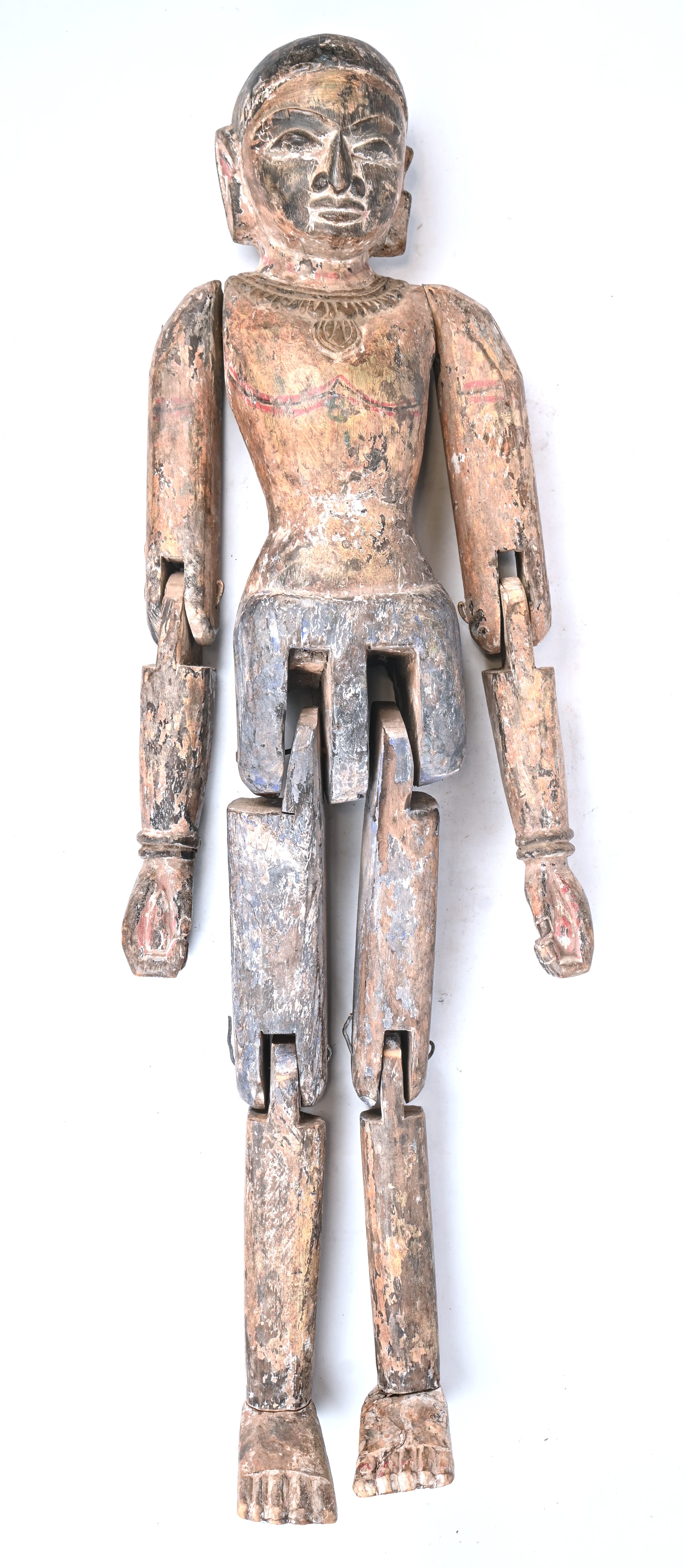Een Aziatisch houten beeld met gescharnierde ledematen. Met resten van polychrome beschildering Een Aziatisch houten beeld met gescharnierde ledematen. Met resten van polychrome beschildering.