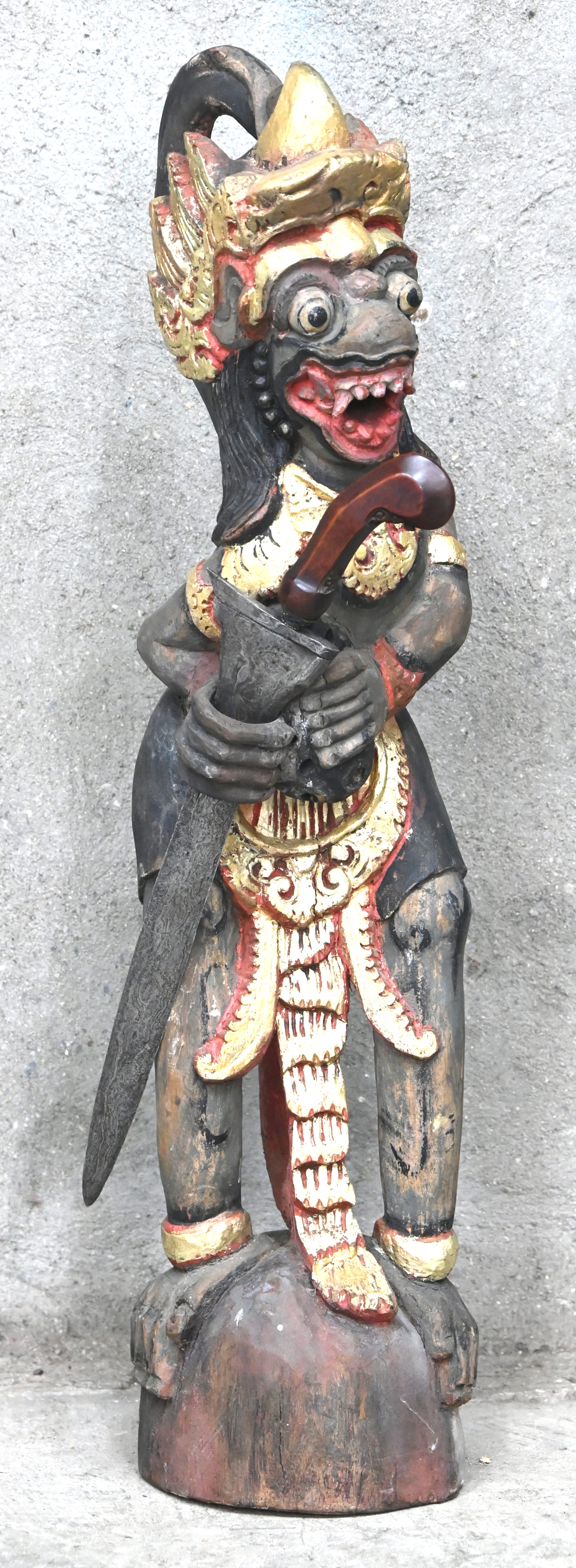 Een polychroom houten beeld van Hanuman, de hindoeïstische godheid in de vorm van een aapmens. Toegevoegd een kris van damaststaal zonder schede Een polychroom houten beeld van Hanuman, de hindoeïstische godheid in de vorm van een aapmens. Toegevoegd een kris van damaststaal zonder schede.
