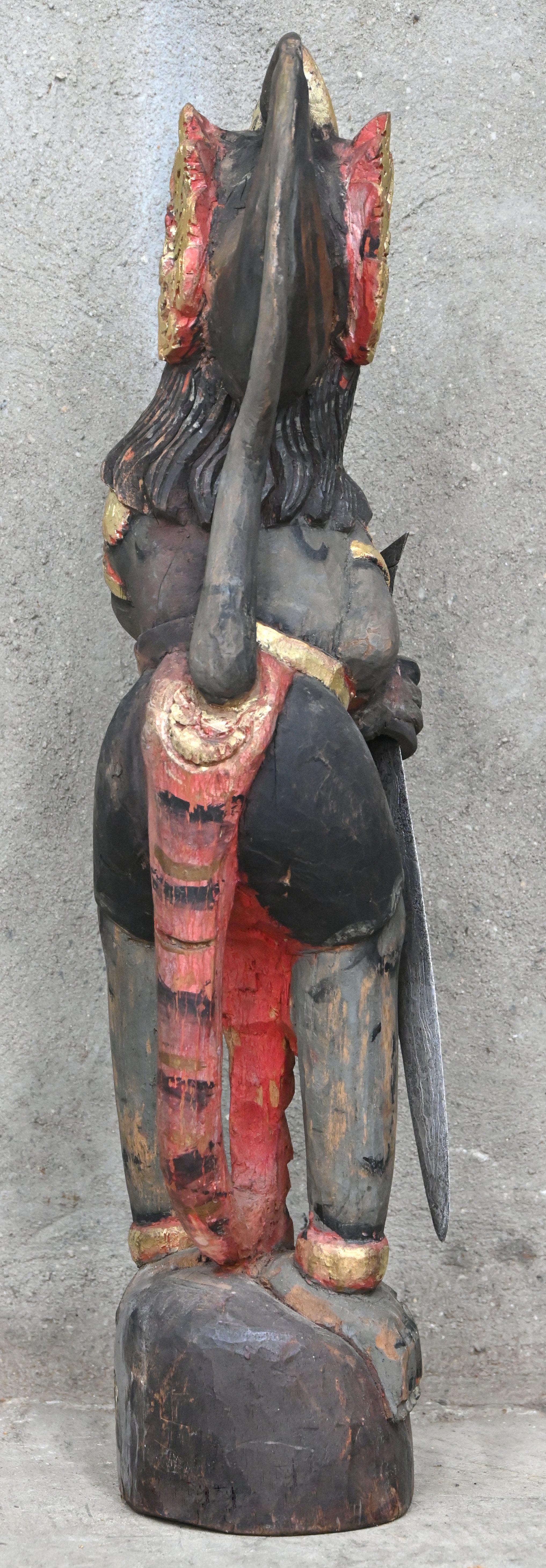Een polychroom houten beeld van Hanuman, de hindoeïstische godheid in de vorm van een aapmens. Toegevoegd een kris van damaststaal zonder schede Een polychroom houten beeld van Hanuman, de hindoeïstische godheid in de vorm van een aapmens. Toegevoegd een kris van damaststaal zonder schede.