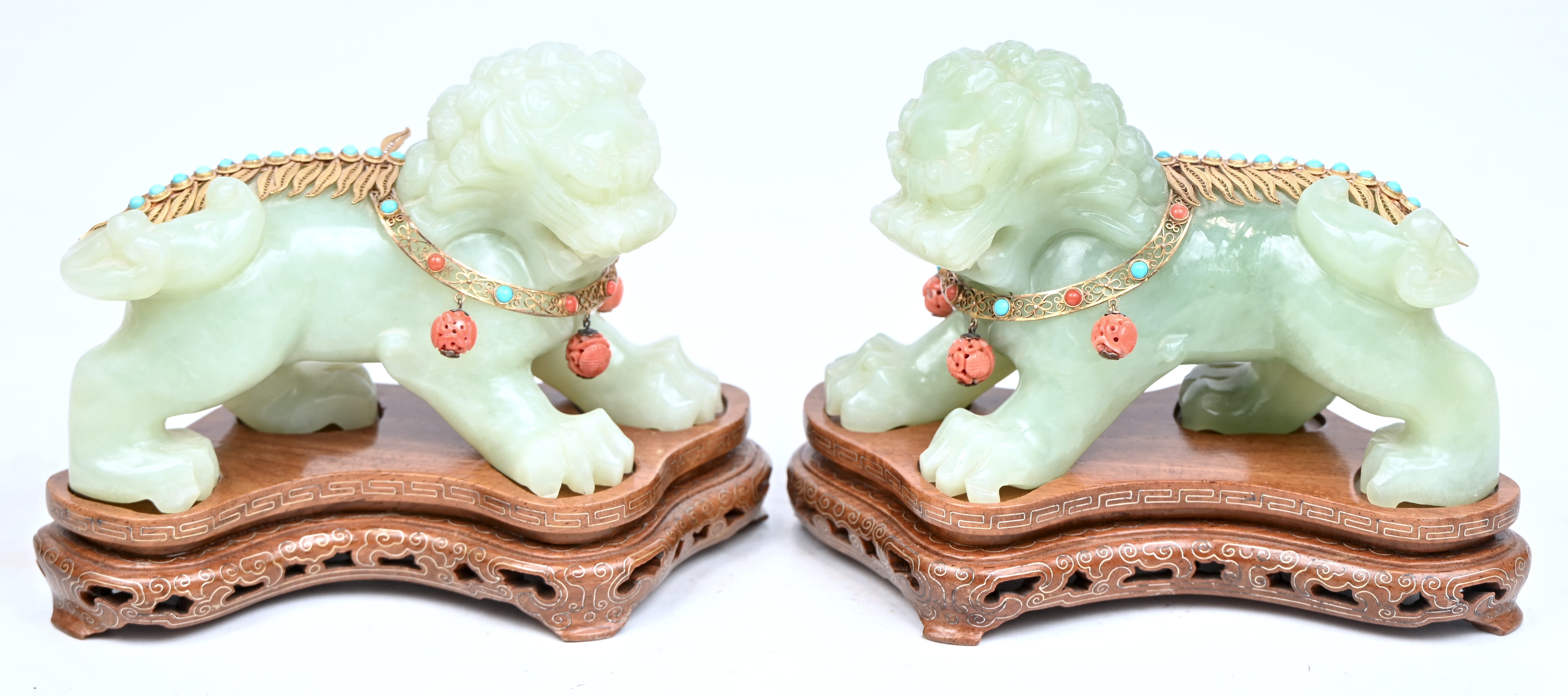 Tempelleeuwen. Twee beelden van jade met 14 kt vergulde ornamenten bezet met turquoise en koraal. Met aankoopbewijs Tempelleeuwen. Twee beelden van jade met 14 kt vergulde ornamenten bezet met turquoise en koraal. Met aankoopbewijs.