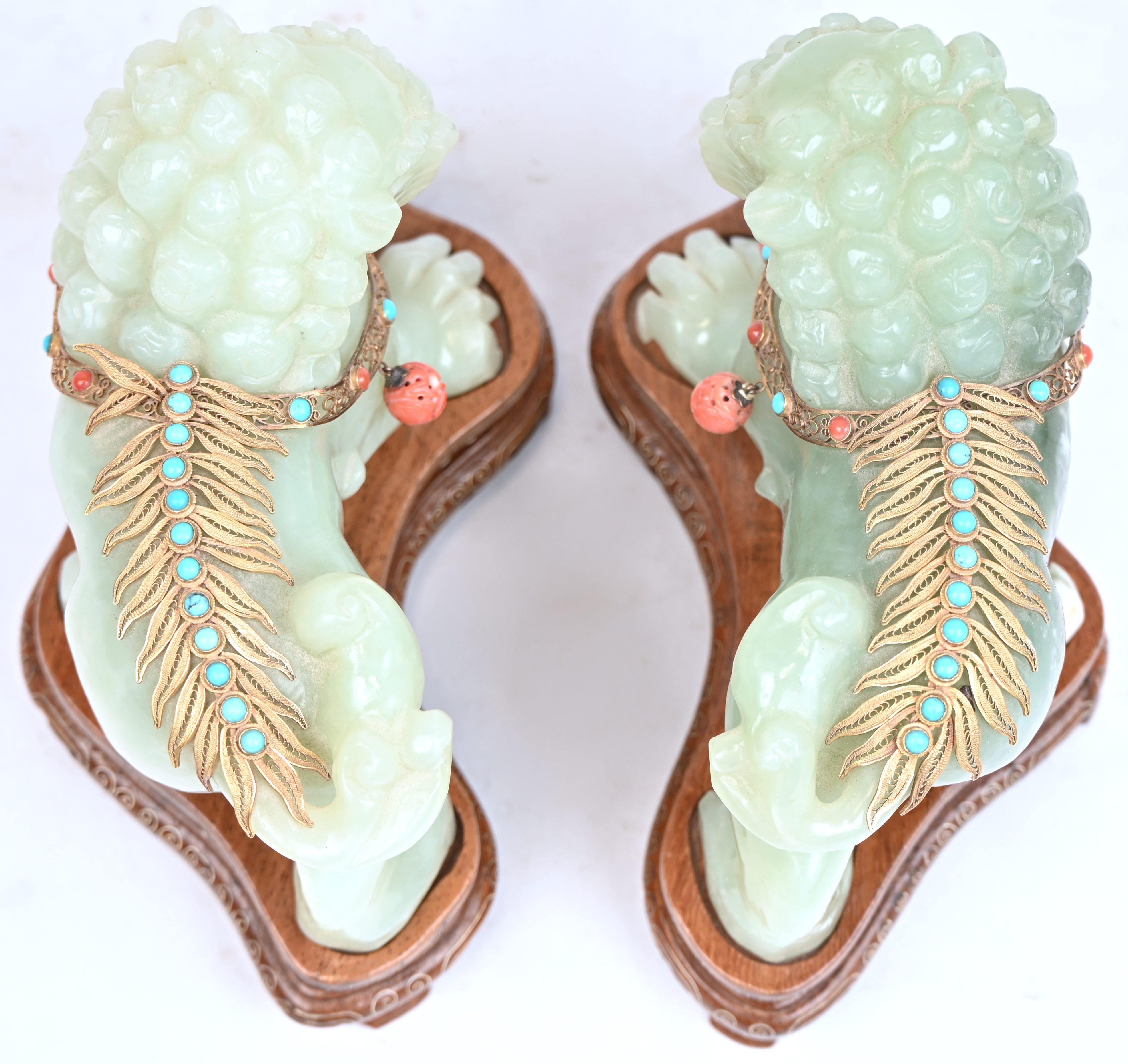 Tempelleeuwen. Twee beelden van jade met 14 kt vergulde ornamenten bezet met turquoise en koraal. Met aankoopbewijs Tempelleeuwen. Twee beelden van jade met 14 kt vergulde ornamenten bezet met turquoise en koraal. Met aankoopbewijs.