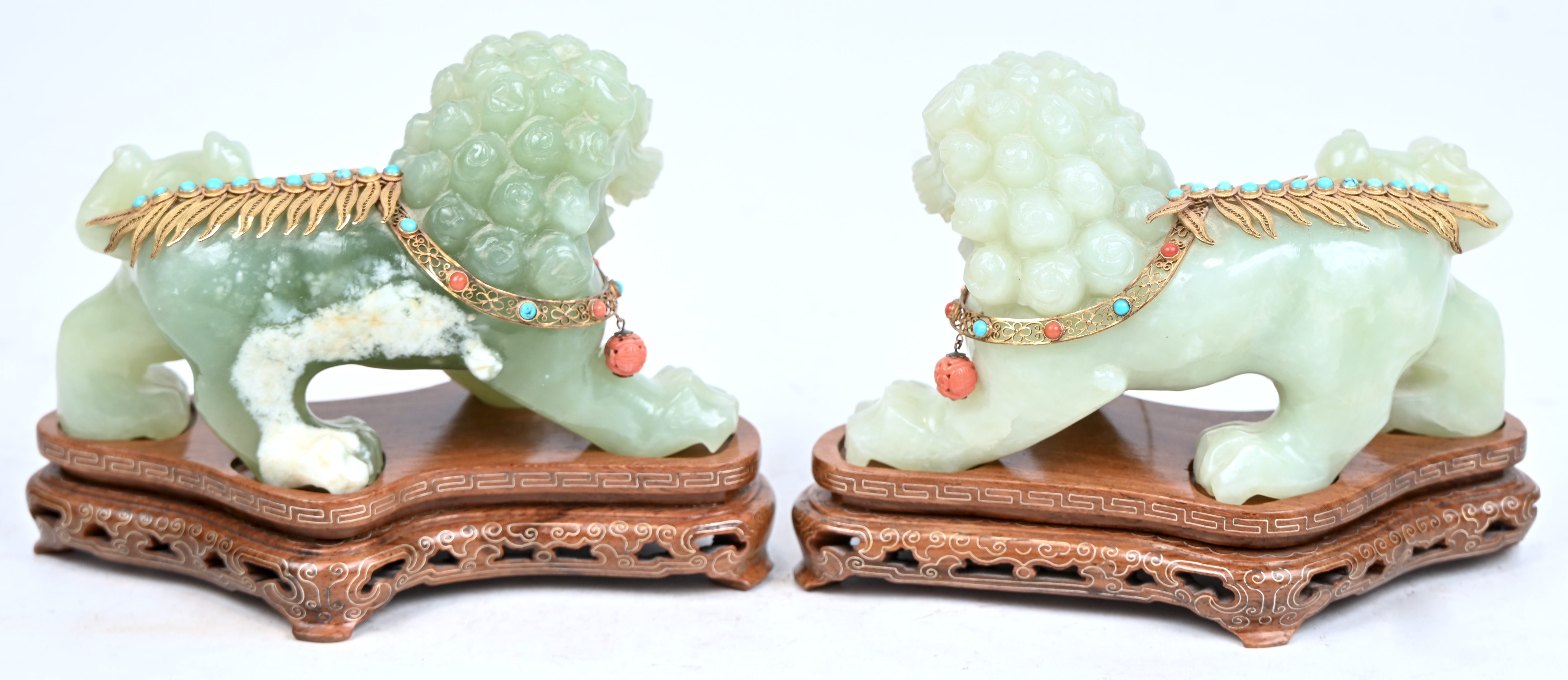 Tempelleeuwen. Twee beelden van jade met 14 kt vergulde ornamenten bezet met turquoise en koraal. Met aankoopbewijs Tempelleeuwen. Twee beelden van jade met 14 kt vergulde ornamenten bezet met turquoise en koraal. Met aankoopbewijs.