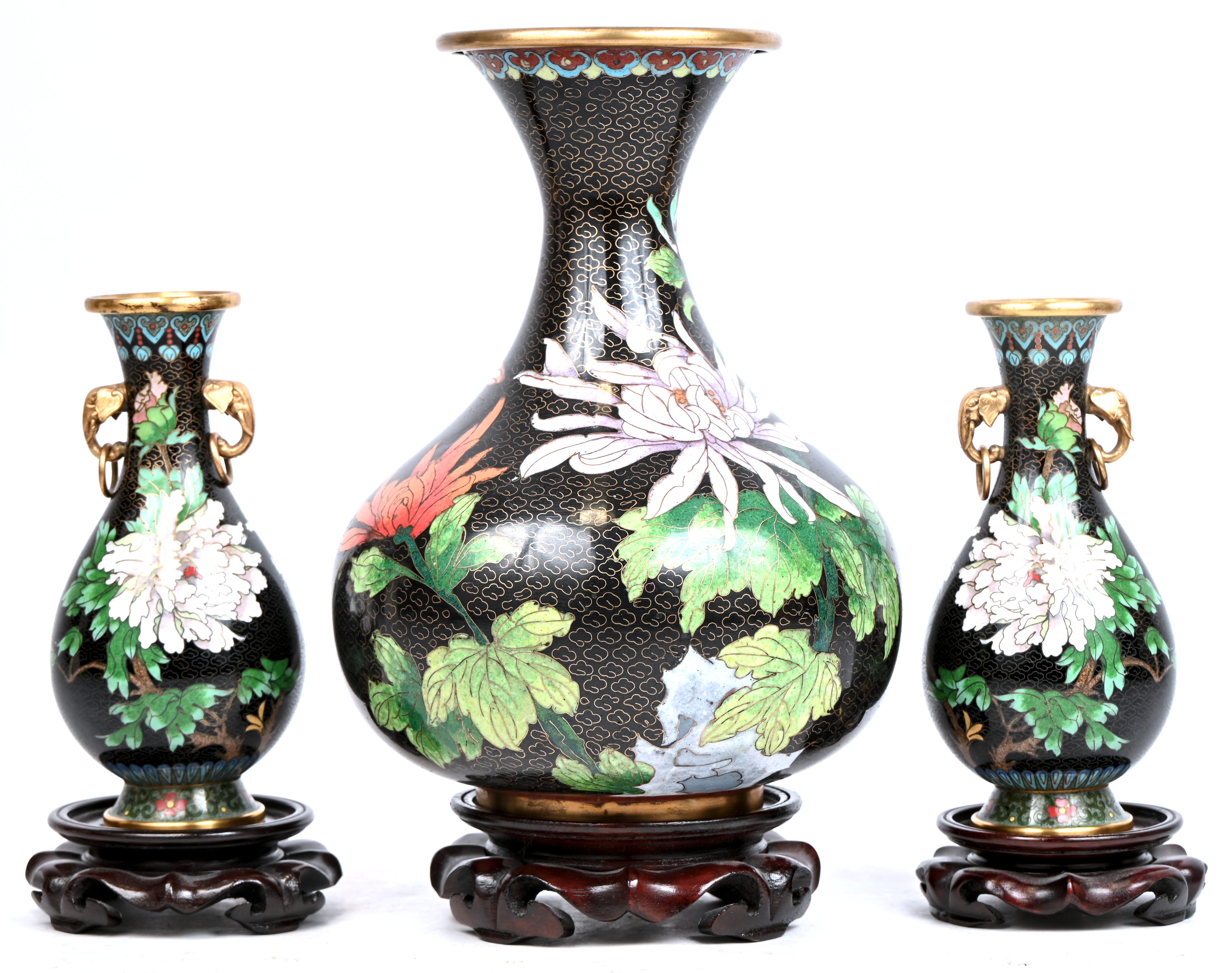 Drie cloisonné vazen met bloemen in het decor Drie cloisonné vazen met bloemen in het decor.