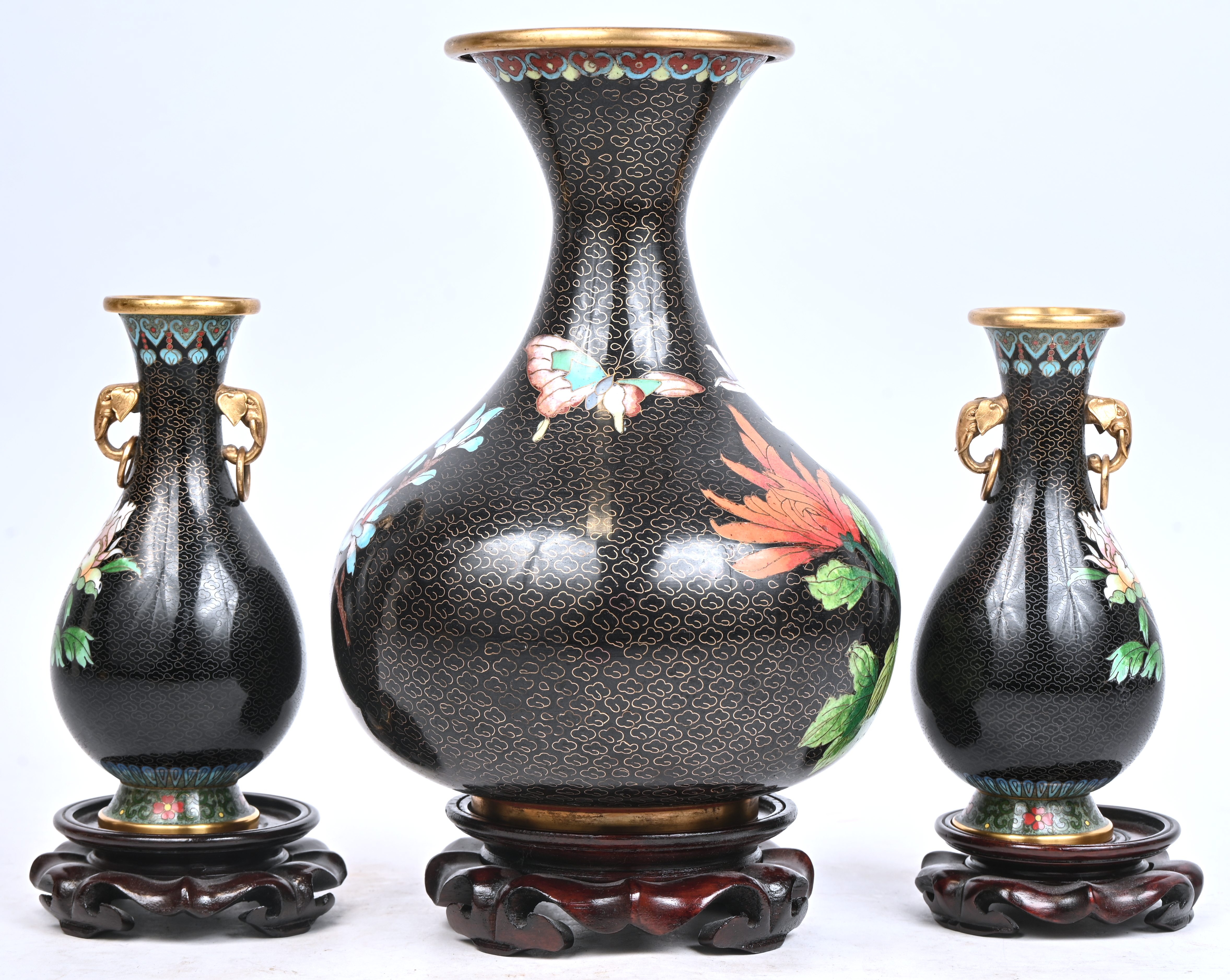 Drie cloisonné vazen met bloemen in het decor Drie cloisonné vazen met bloemen in het decor.