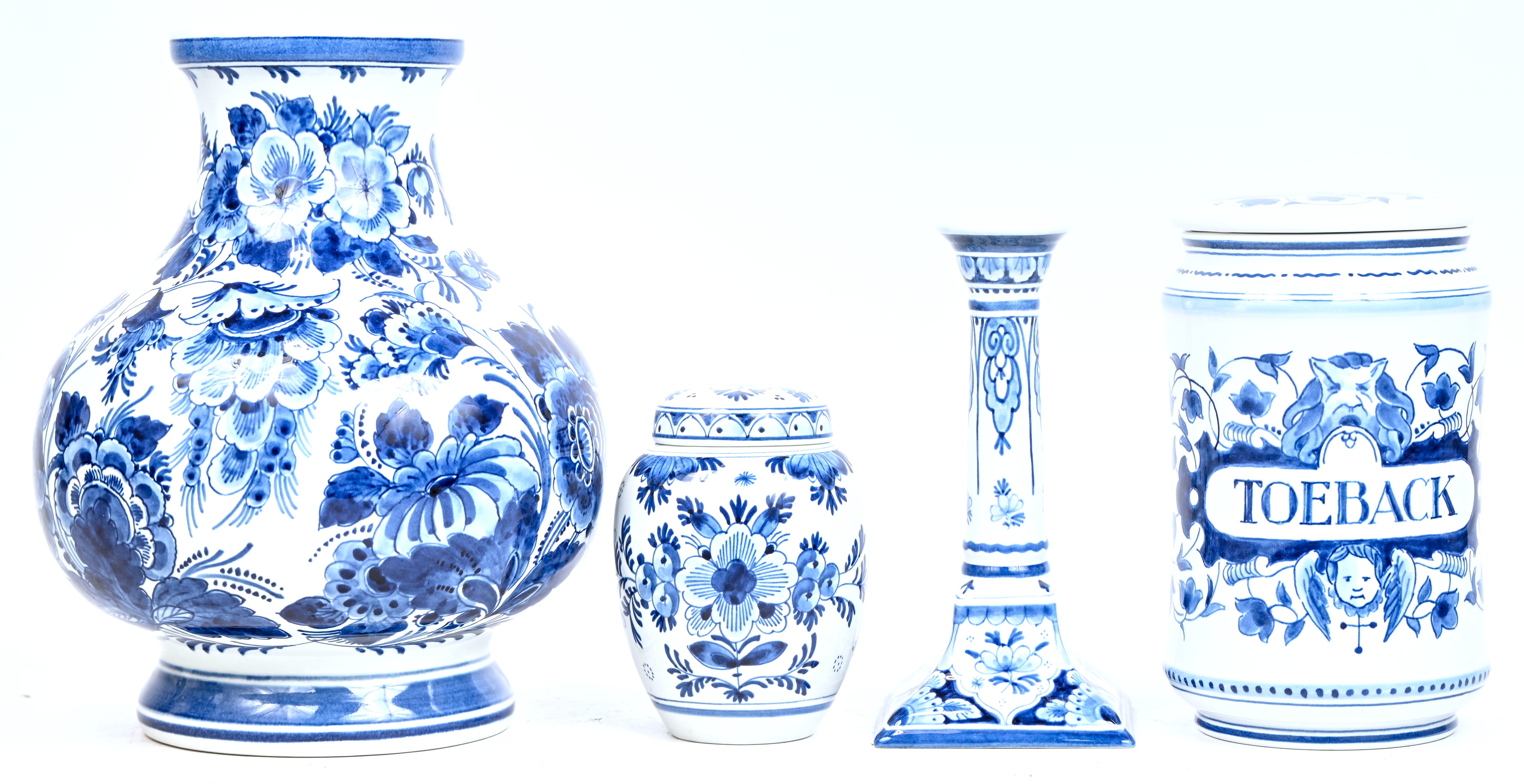 Een dekselpotje, een kandelaar, een tabakspot en een vaas van blauw-wit geglazuurd Delfts aardewerk. Gemerkt ‘De Porceleyne Fles’ Een dekselpotje, een kandelaar, een tabakspot en een vaas van blauw-wit geglazuurd Delfts aardewerk. Gemerkt ‘De Porceleyne Fles’.