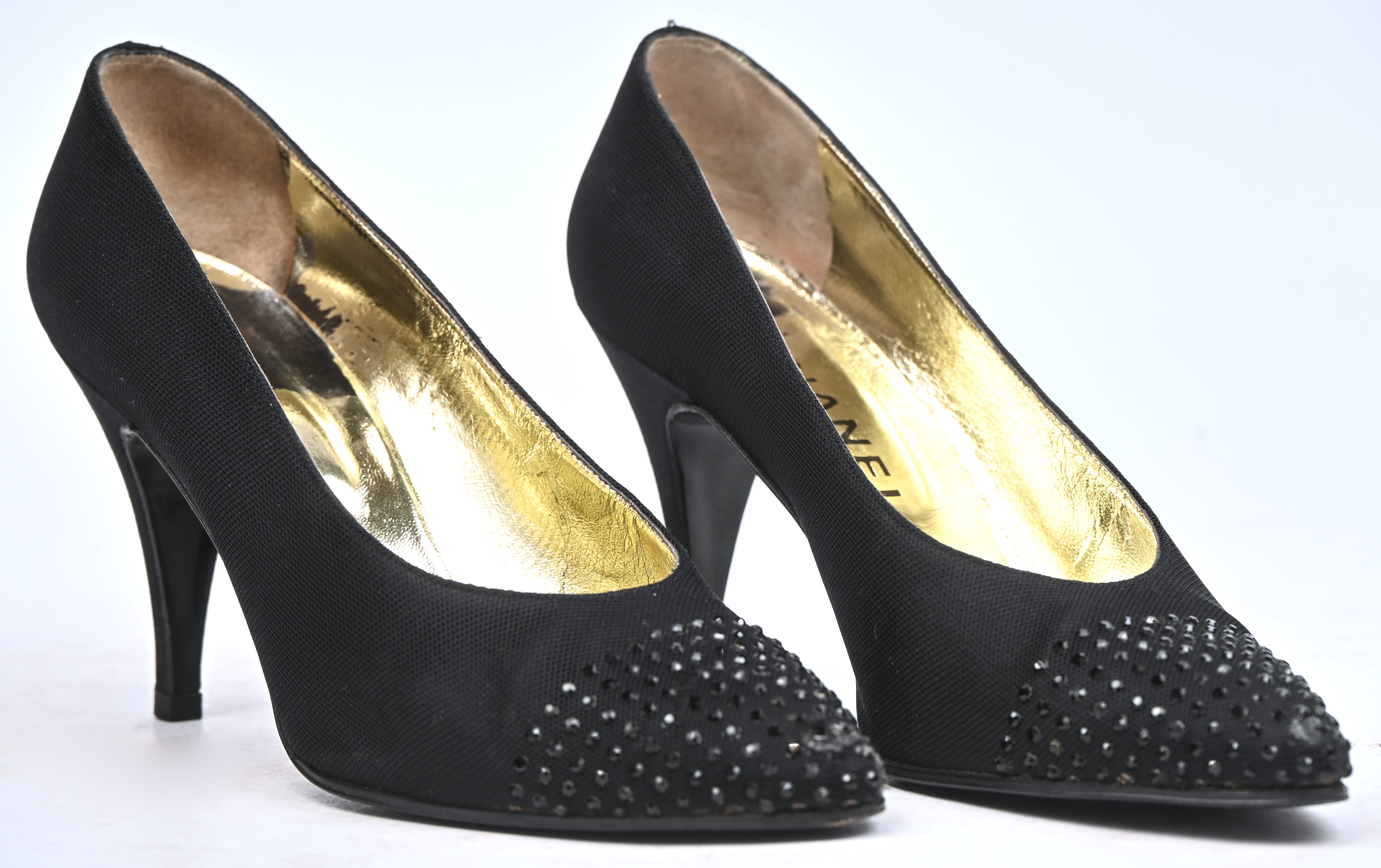 Ene paar vintage Chanel pumps, maat 37. Zwart satijn met zwarte siersteentjes op de neus. In goede gedragen staat Ene paar vintage Chanel pumps, maat 37. Zwart satijn met zwarte siersteentjes op de neus. In goede gedragen staat.