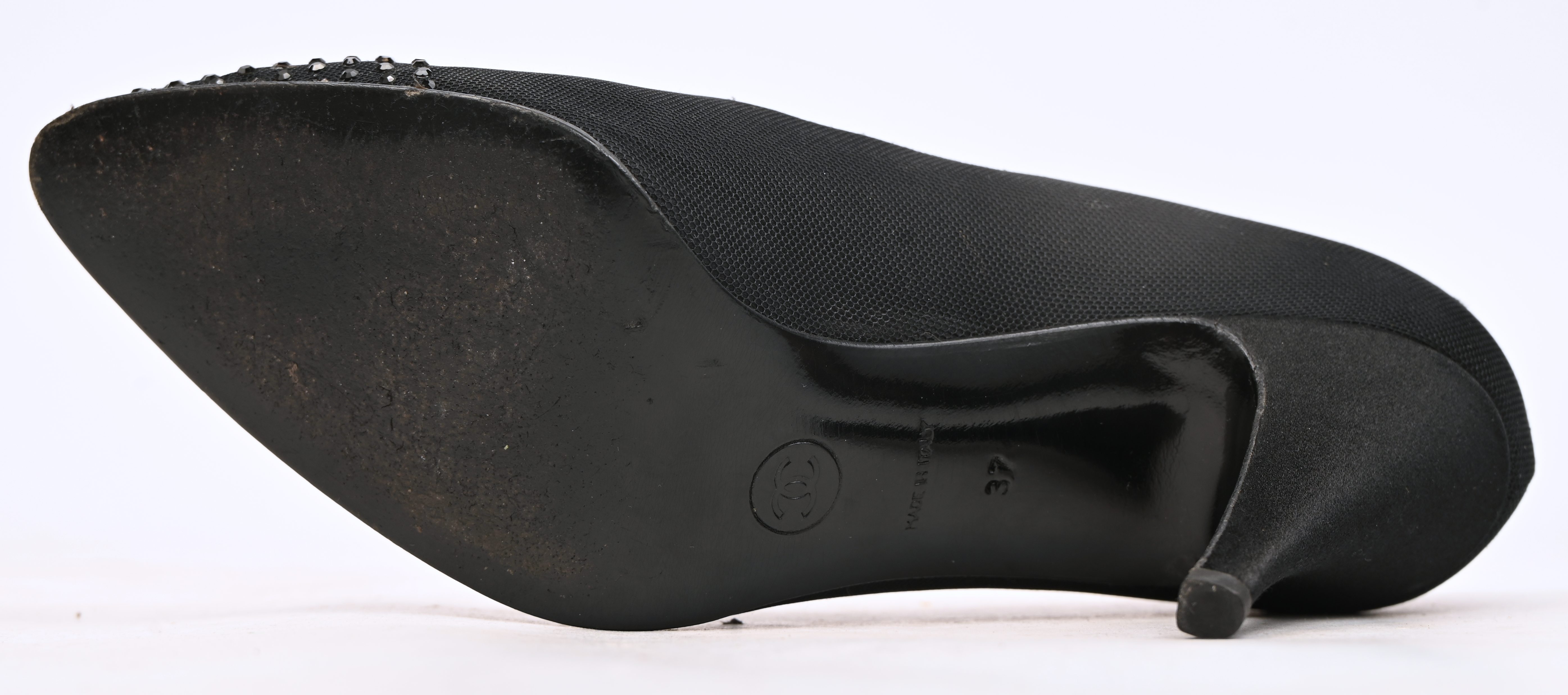 Ene paar vintage Chanel pumps, maat 37. Zwart satijn met zwarte siersteentjes op de neus. In goede gedragen staat Ene paar vintage Chanel pumps, maat 37. Zwart satijn met zwarte siersteentjes op de neus. In goede gedragen staat.