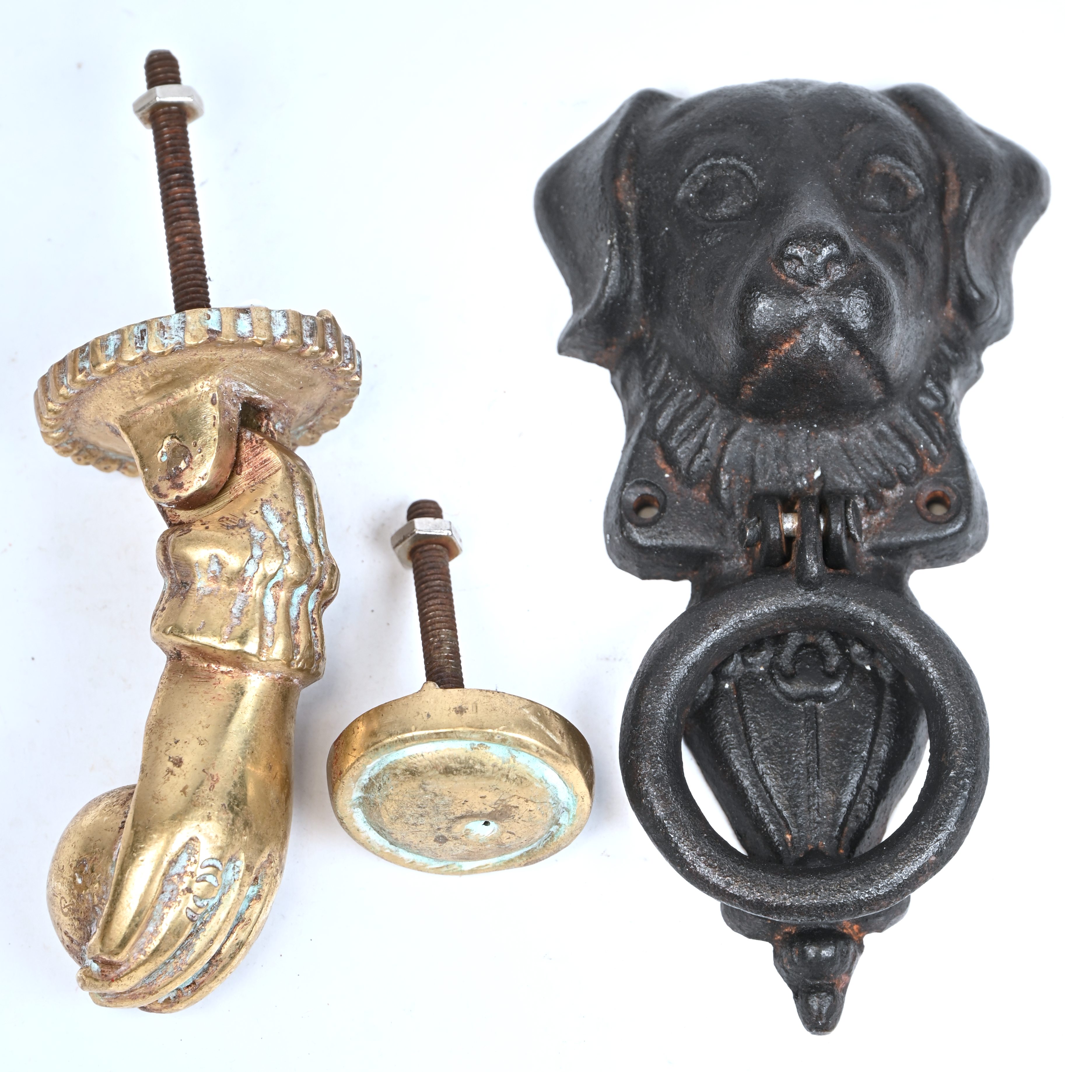 Twee deurkloppers in de vorm van een hand in brons en een hond van ijzer Twee deurkloppers in de vorm van een hand in brons en een hond van ijzer.