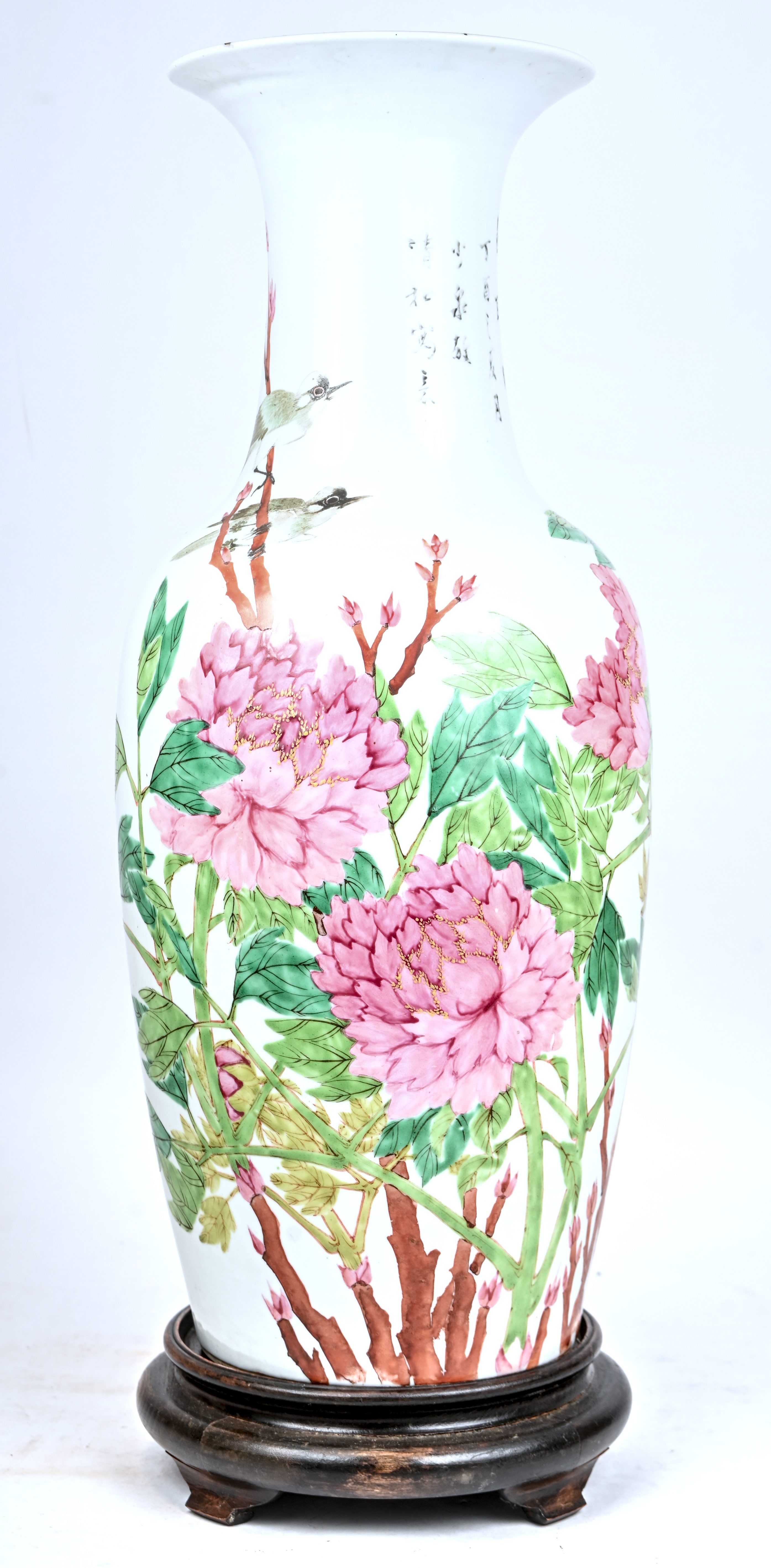 Een Chinees porseleinen vaas, famille rose, met pioenrozen en vogels gedecoreerd. Op houten sokkel. Stervormige haarlijn op de bodem, kleine chip aan de hals Een Chinees porseleinen vaas, famille rose, met pioenrozen en vogels gedecoreerd. Op houten sokkel. Stervormige haarlijn op de bodem, kleine chip aan de hals.