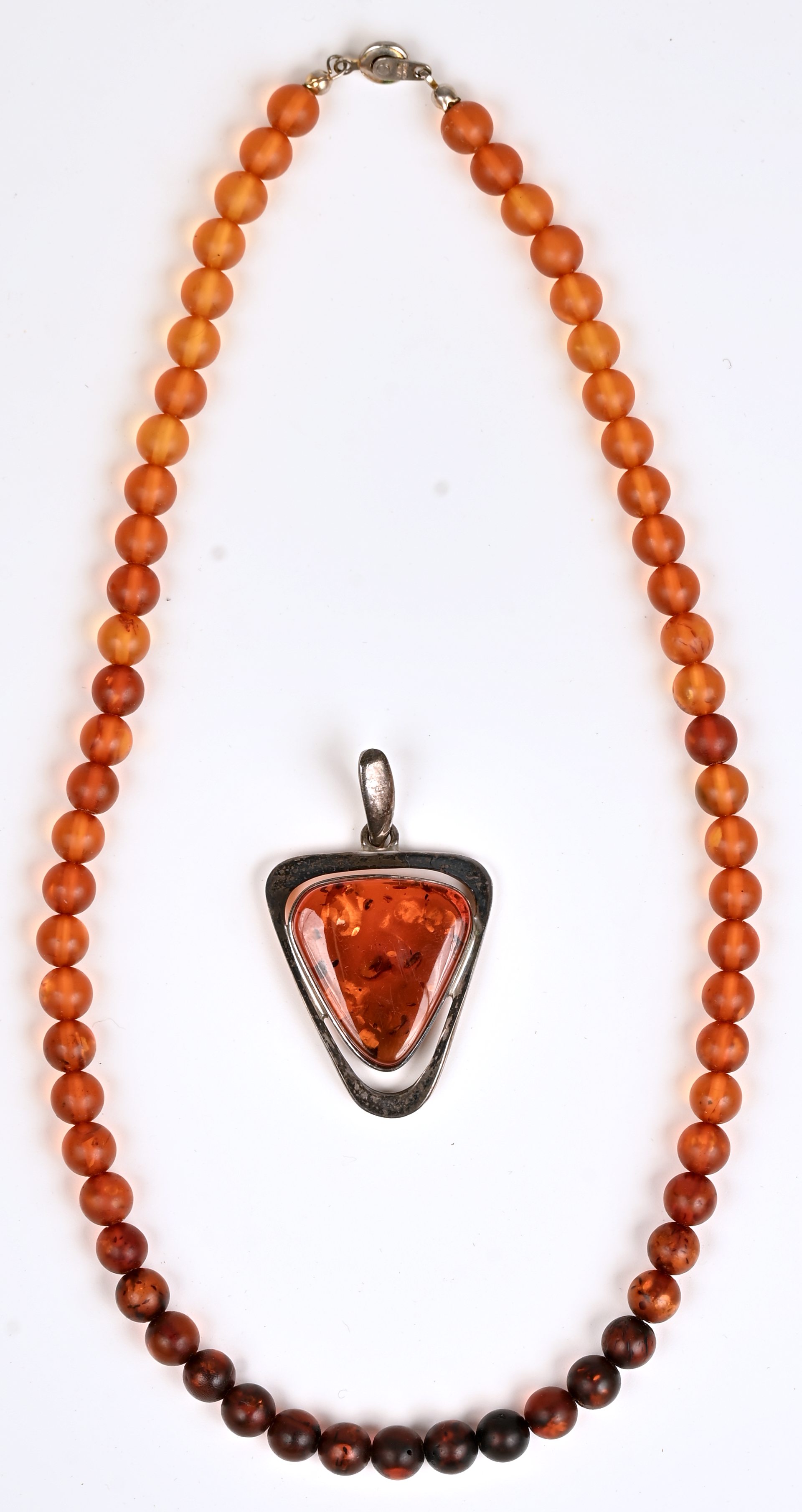 Een halssnoer van amber en een hanger van zilver bezet met amber. 925‰ Een halssnoer van amber en een hanger van zilver bezet met amber. 925‰.