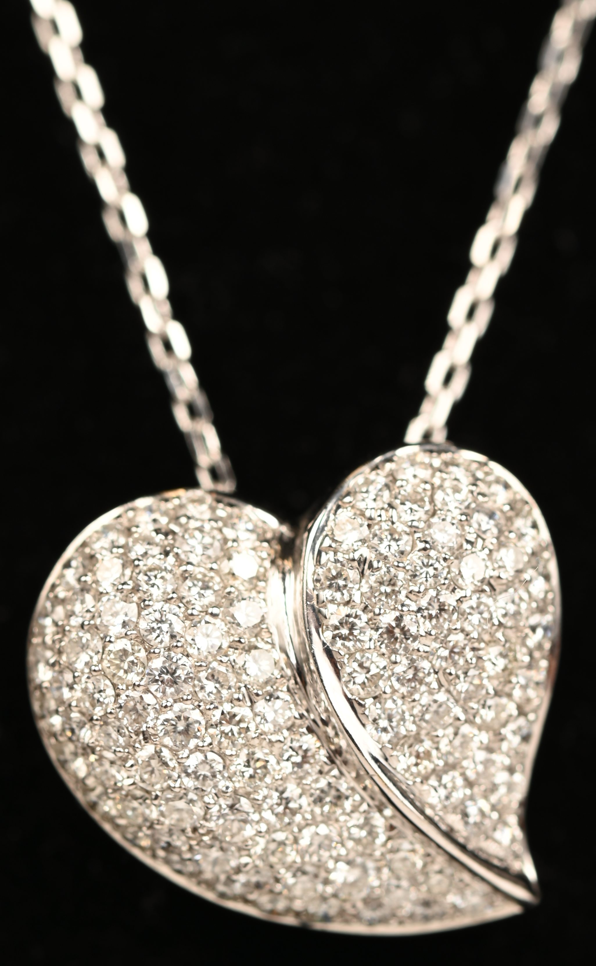 Een 18 kt witgouden ketting met hartvormige hanger bezet met briljanten met een gezamenlijk gewicht van +- 1,26 ct Een 18 kt witgouden ketting met hartvormige hanger bezet met briljanten met een gezamenlijk gewicht van +- 1,26 ct.