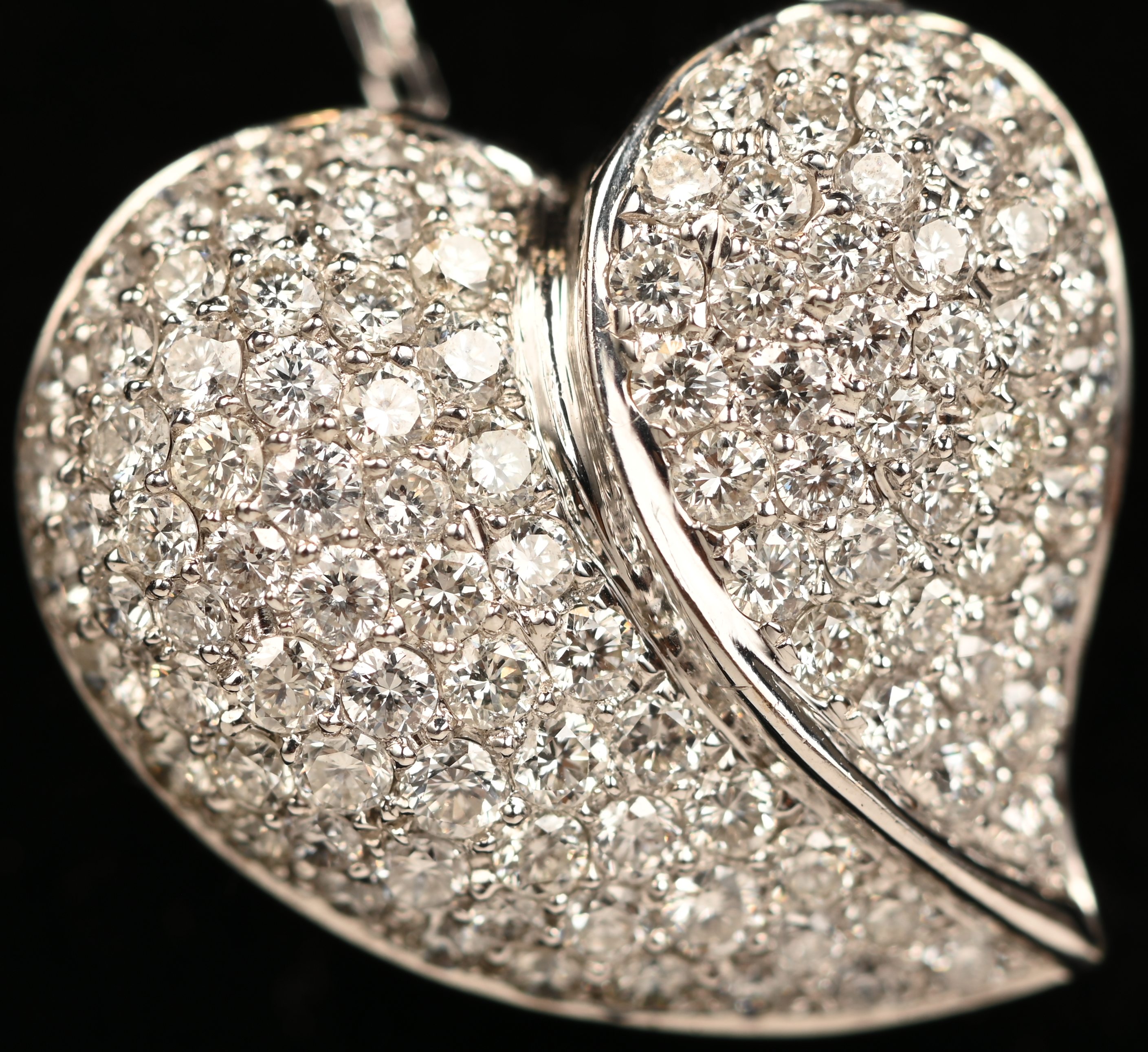 Een 18 kt witgouden ketting met hartvormige hanger bezet met briljanten met een gezamenlijk gewicht van +- 1,26 ct Een 18 kt witgouden ketting met hartvormige hanger bezet met briljanten met een gezamenlijk gewicht van +- 1,26 ct.