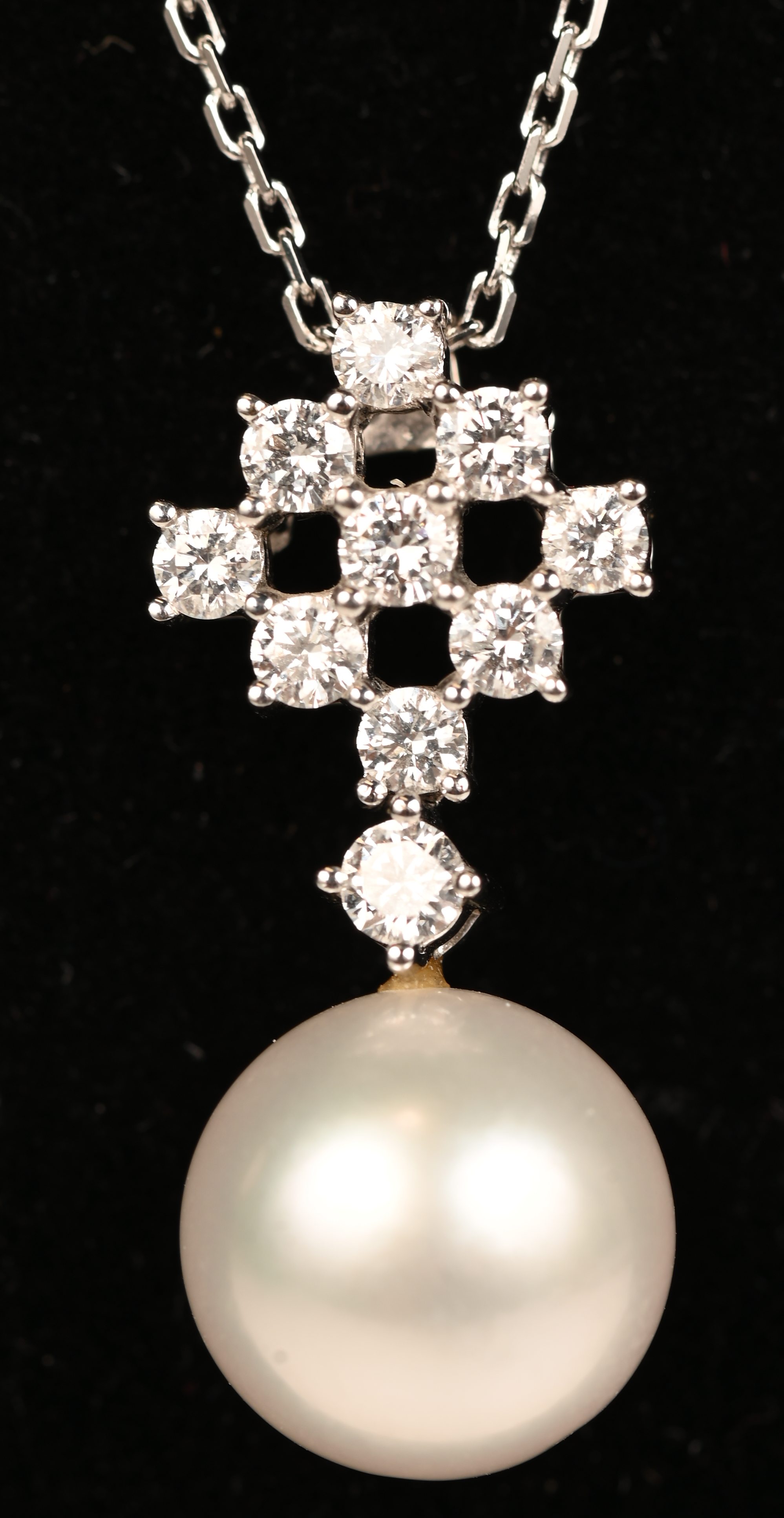 Een 18 kt witgouden ketting met hanger met parel (11 mm) bezet met briljanten met een gezamenlijk gewicht van +- 0,52 ct. EVVS Een 18 kt witgouden ketting met hanger met parel (11 mm) bezet met briljanten met een gezamenlijk gewicht van +- 0,52 ct. EVVS.