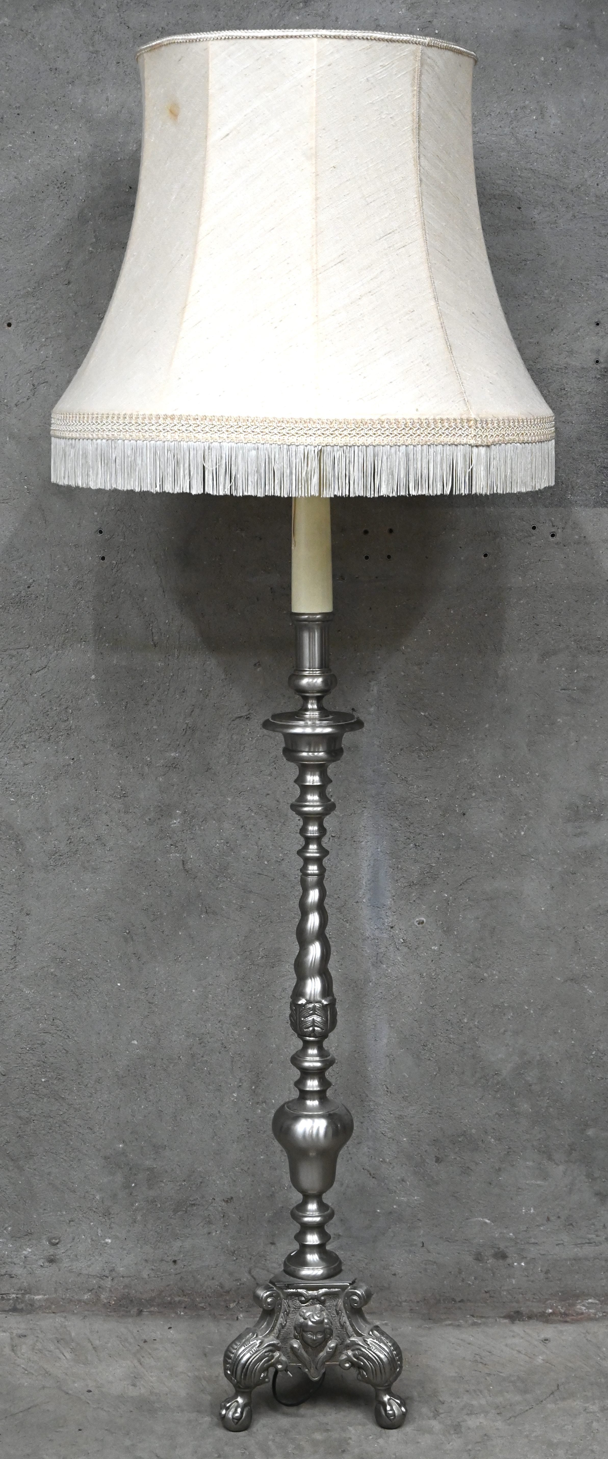 Een klassieke staanlamp met tinkleurige koperen voet Een klassieke staanlamp met tinkleurige koperen voet.