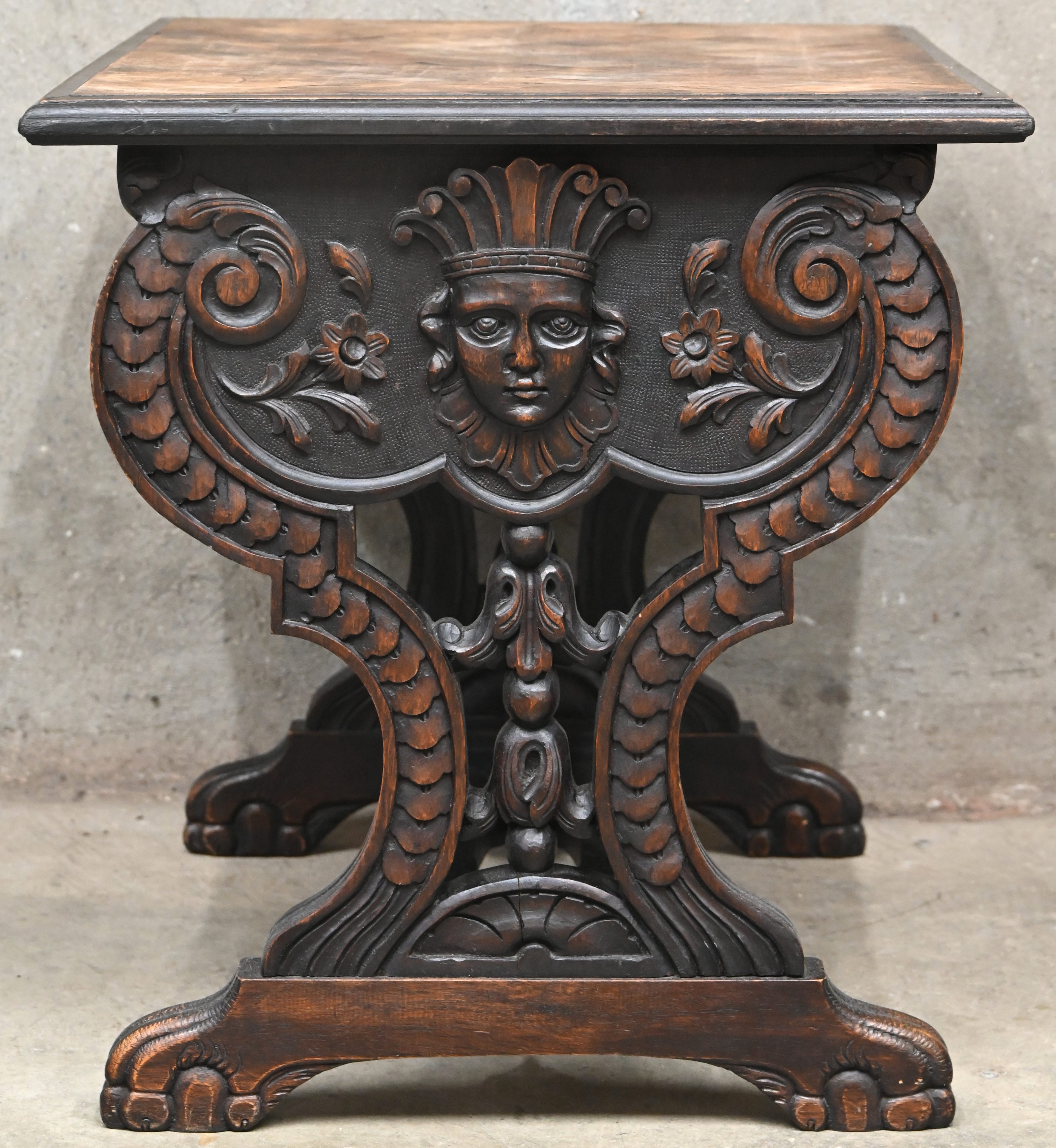 Een massief eikenhouten gesculpteerd bijzettafeltje met geparketteerd blad Een massief eikenhouten gesculpteerd bijzettafeltje met geparketteerd blad.