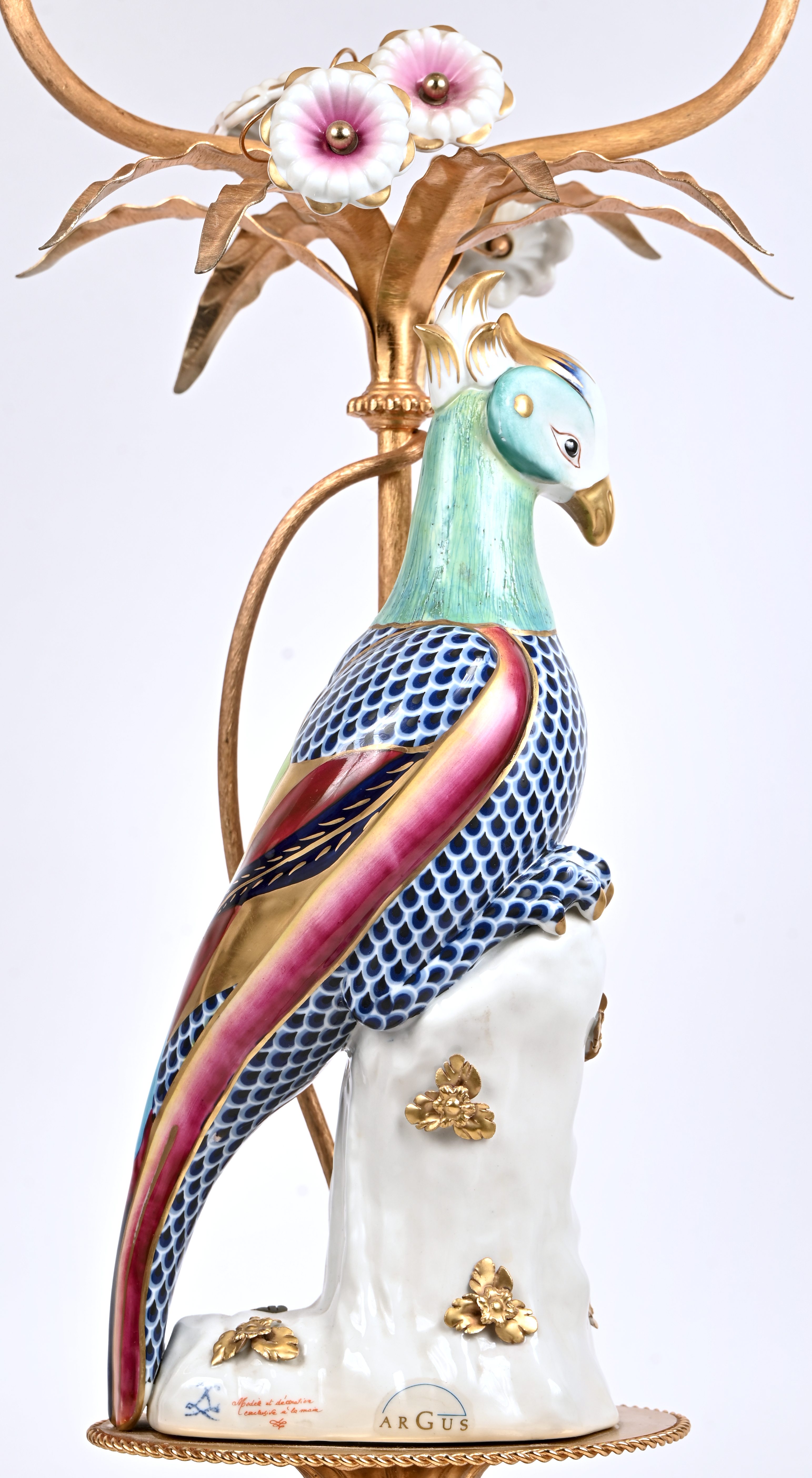 Een tafellamp, porseleinen vogel en messing voet met een merkteken in de stijl van Sèvres en opschrift Argus Een tafellamp, porseleinen vogel en messing voet met een merkteken in de stijl van Sèvres en opschrift Argus.