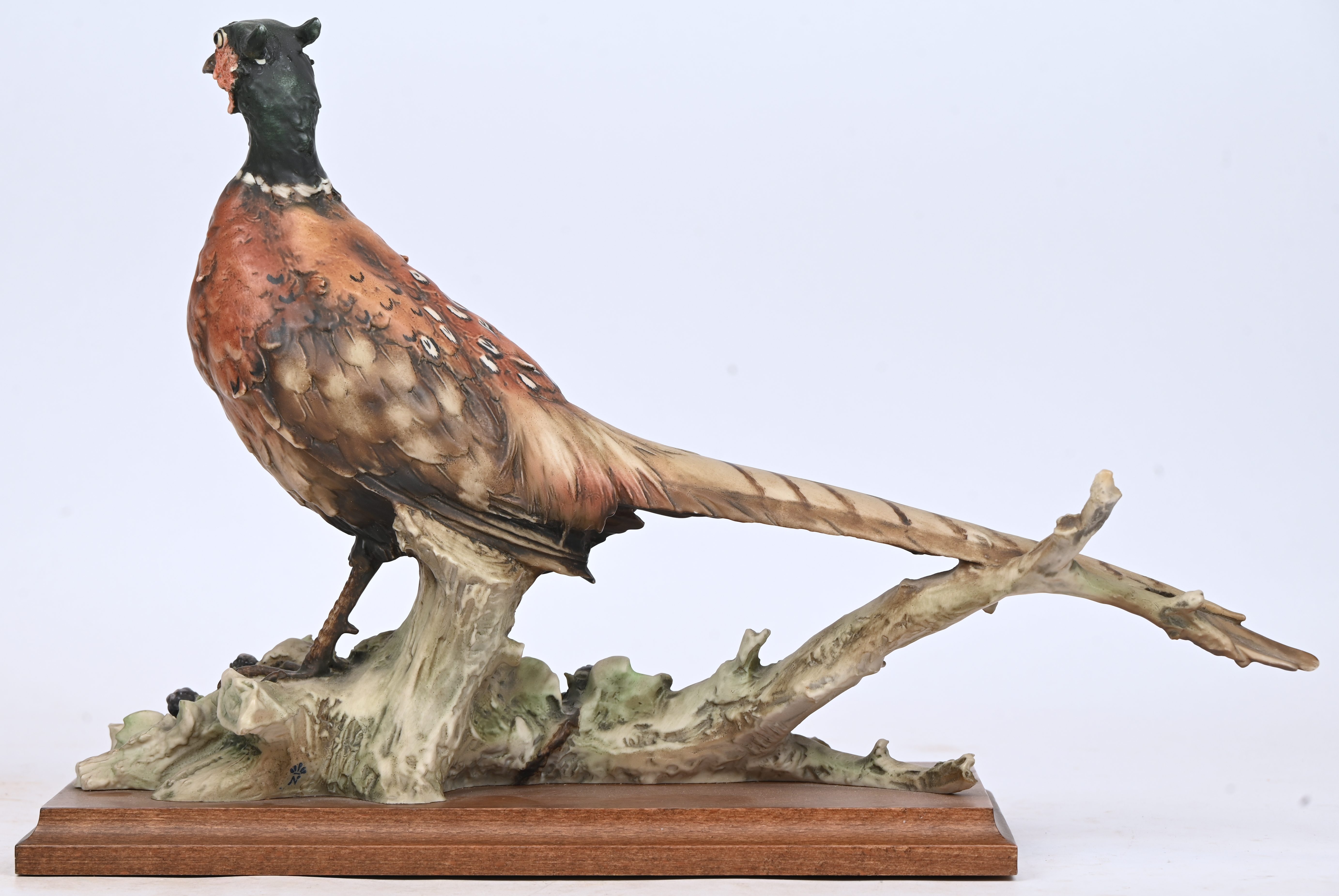 Een gegoten kunsthars beeld van een fazant, gemerkt G. Armani, Capodimonte. Op houten sokkel Een gegoten kunsthars beeld van een fazant, gemerkt G. Armani, Capodimonte. Op houten sokkel.