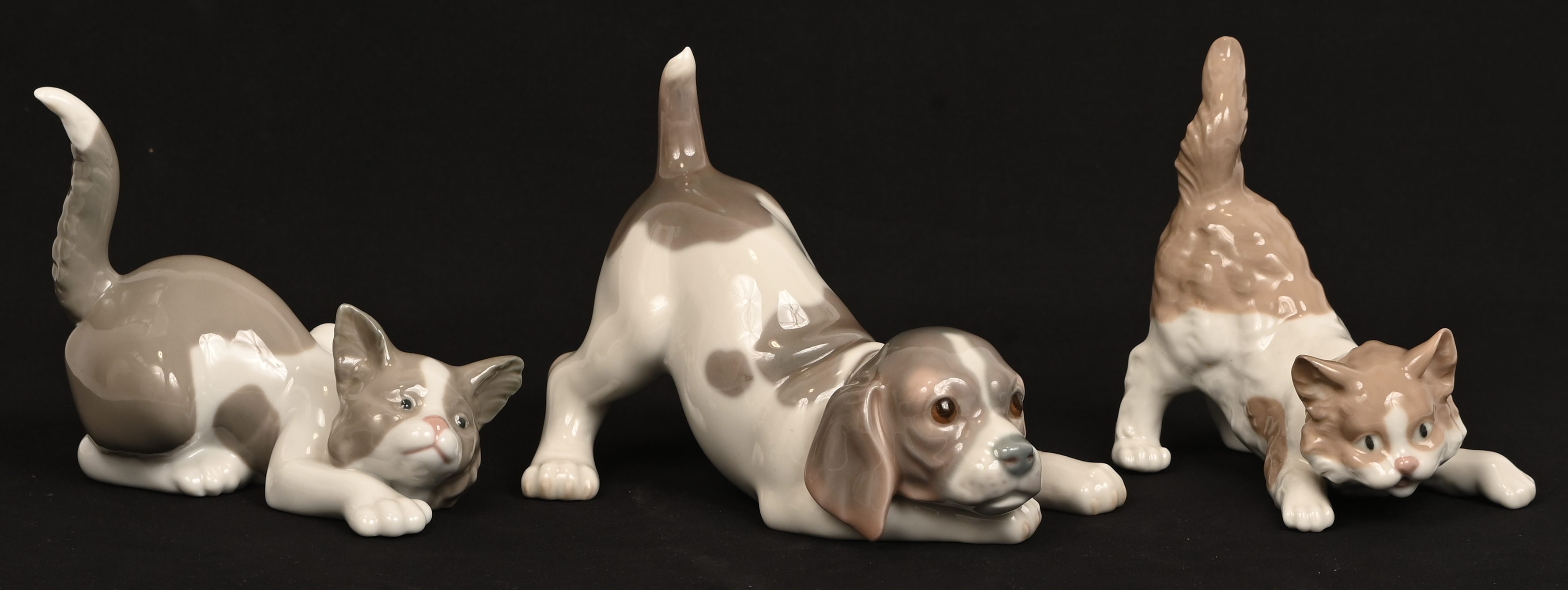 Drie porseleinen beeldjes, twee poezen en een hond, gemerkt Lladro Drie porseleinen beeldjes, twee poezen en een hond, gemerkt Lladro.