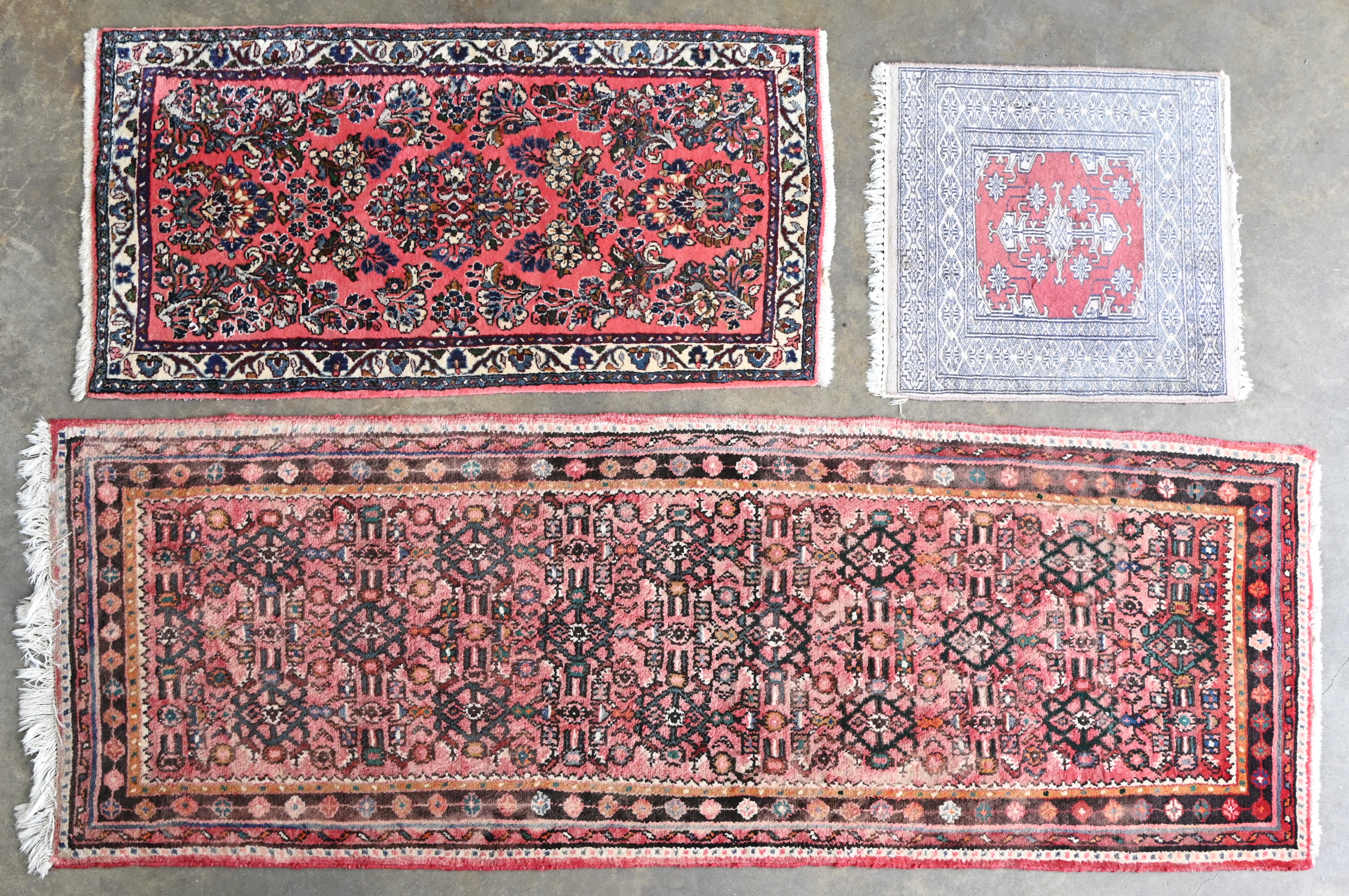 Een lot van drie handgeknoopte Oosterse tapijtjes Een lot van drie handgeknoopte Oosterse tapijtjes. 76/216, 66/130 en 62/62 cm