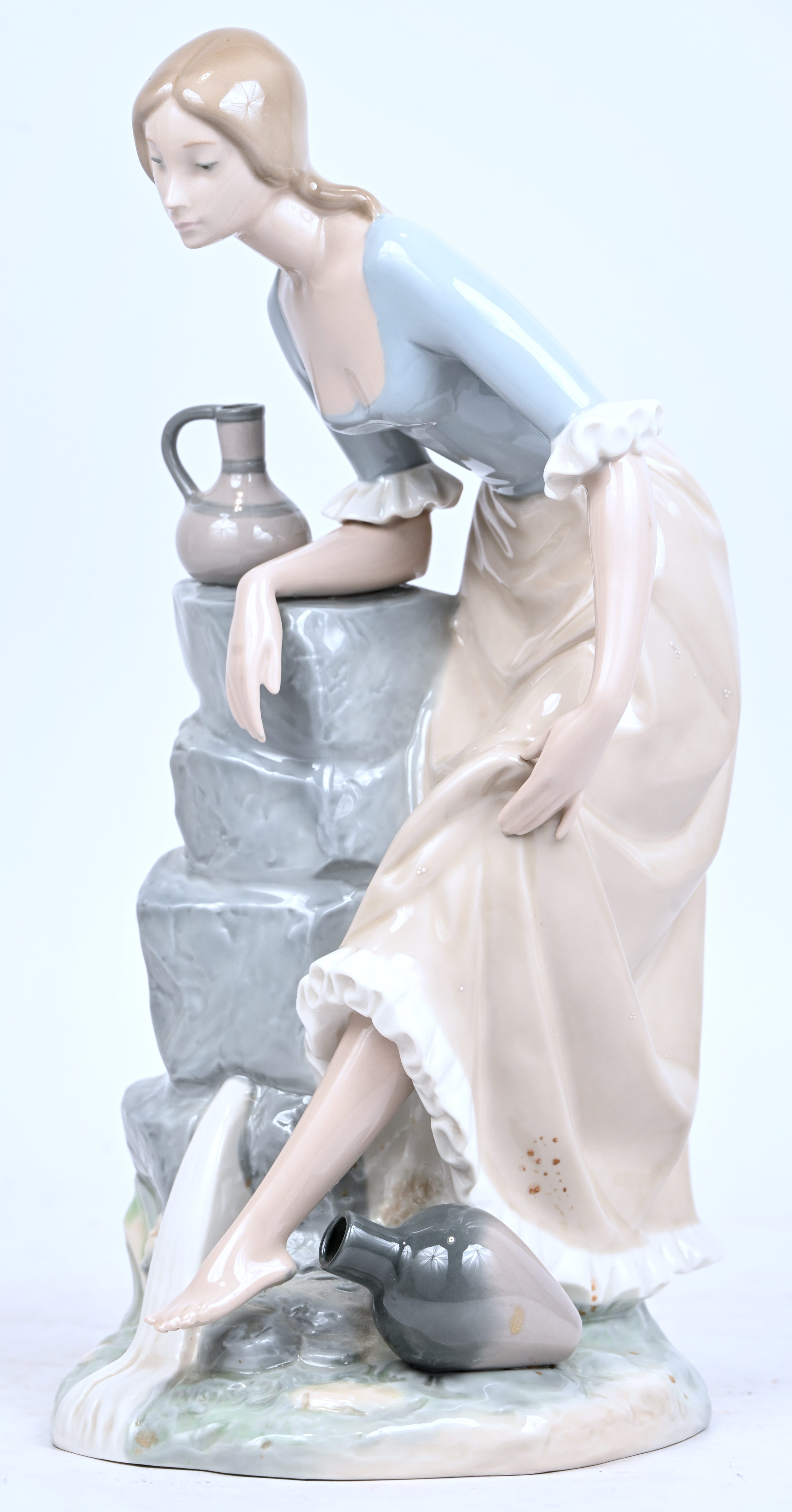‘Jonge vrouw met waterkruik’, een porseleinen beeldje door Nao by Lladro ‘Jonge vrouw met waterkruik’, een porseleinen beeldje door Nao by Lladro.