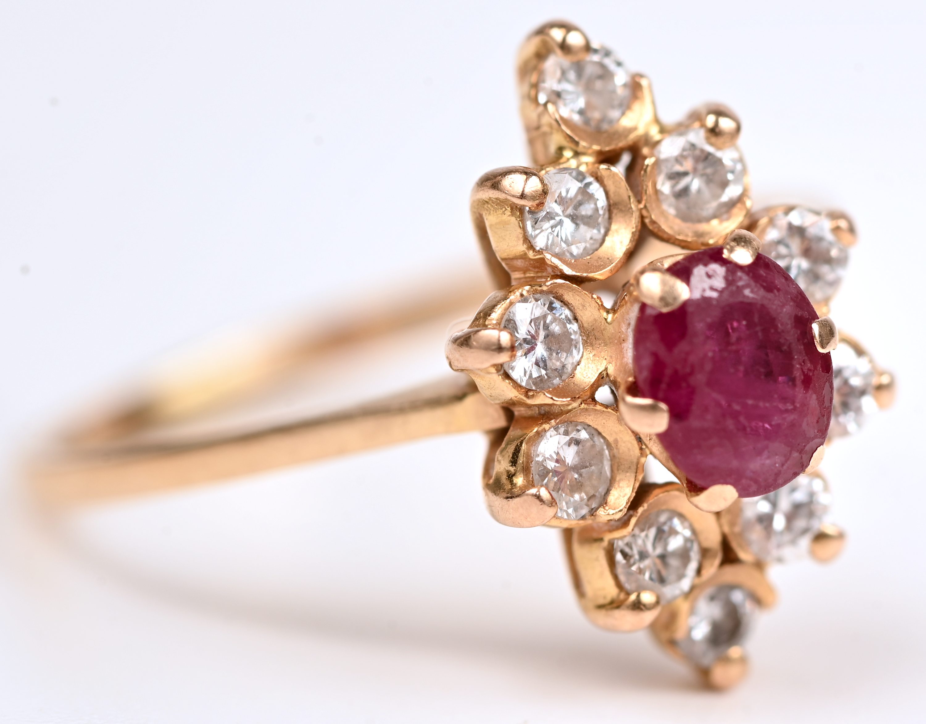 Een 18 kt geelgouden ring bezet met een centrale robijn van +- 0,30 ct. en briljanten met een gezamenlijk gewicht van +- 0,40 ct Een 18 kt geelgouden ring bezet met een centrale robijn van +- 0,30 ct. en briljanten met een gezamenlijk gewicht van +- 0,40 ct.