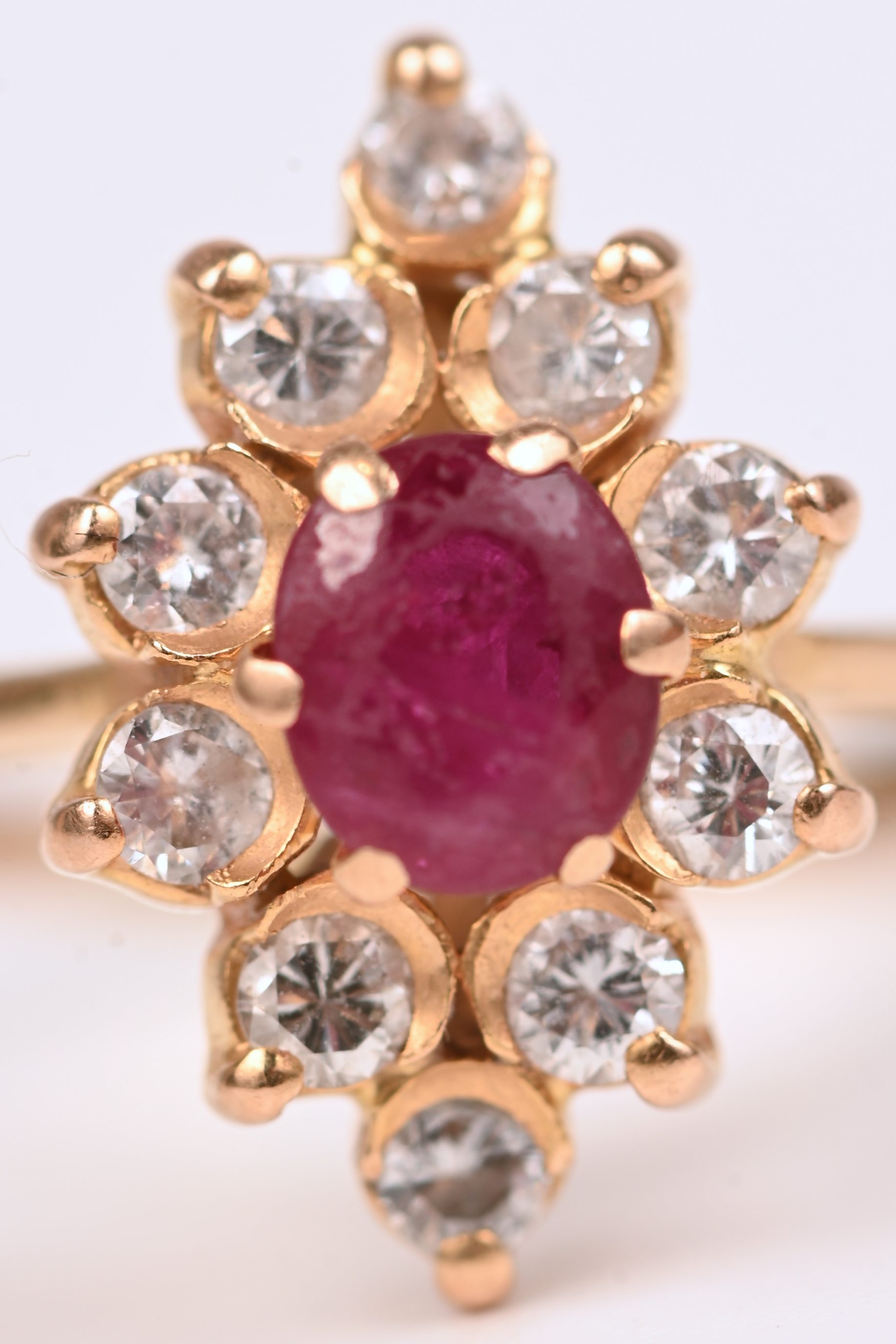 Een 18 kt geelgouden ring bezet met een centrale robijn van +- 0,30 ct. en briljanten met een gezamenlijk gewicht van +- 0,40 ct Een 18 kt geelgouden ring bezet met een centrale robijn van +- 0,30 ct. en briljanten met een gezamenlijk gewicht van +- 0,40 ct.