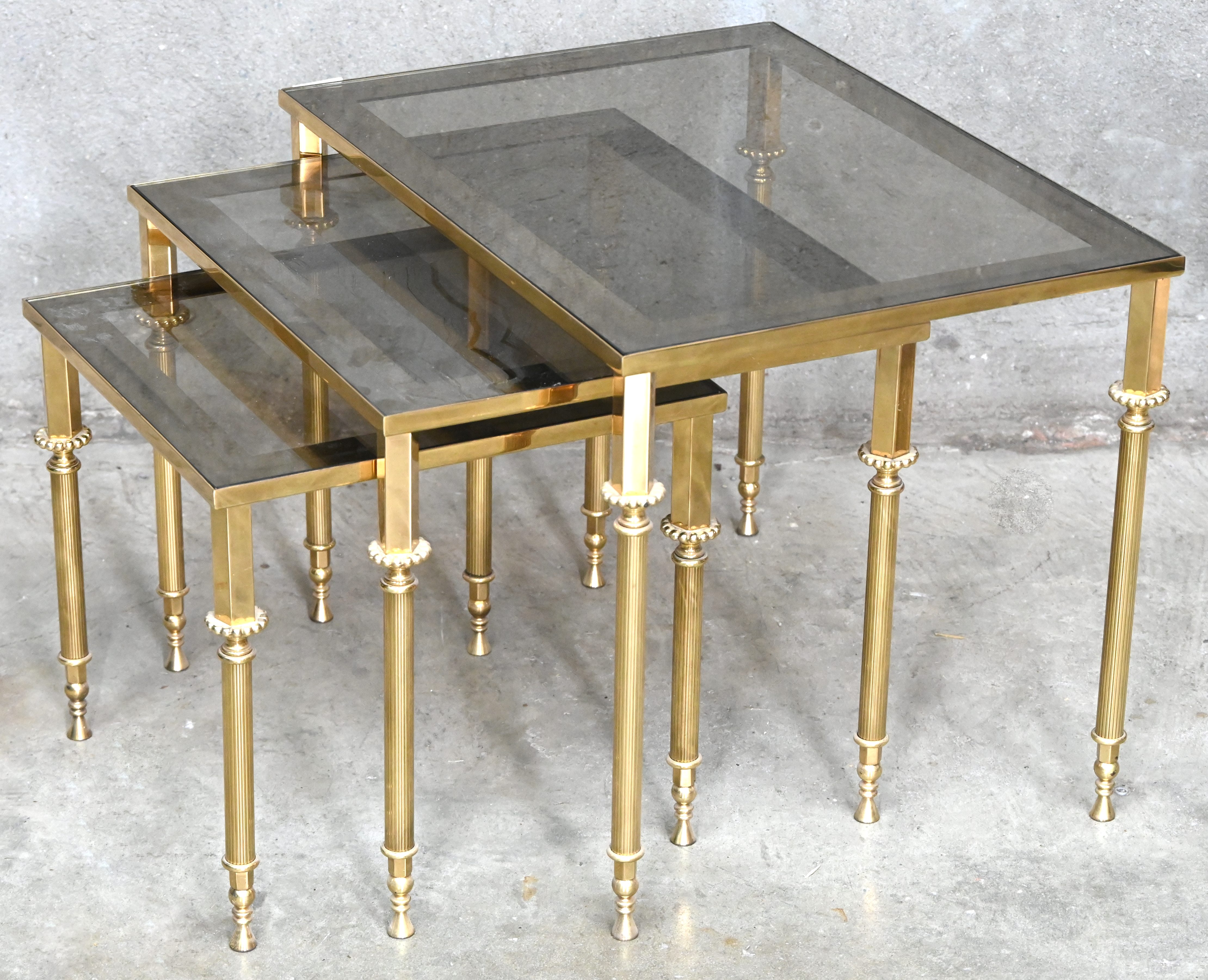 Een set van 3 bijzettafeltjes in regency stijl, messing en glas Een set van 3 bijzettafeltjes in regency stijl, messing en glas.