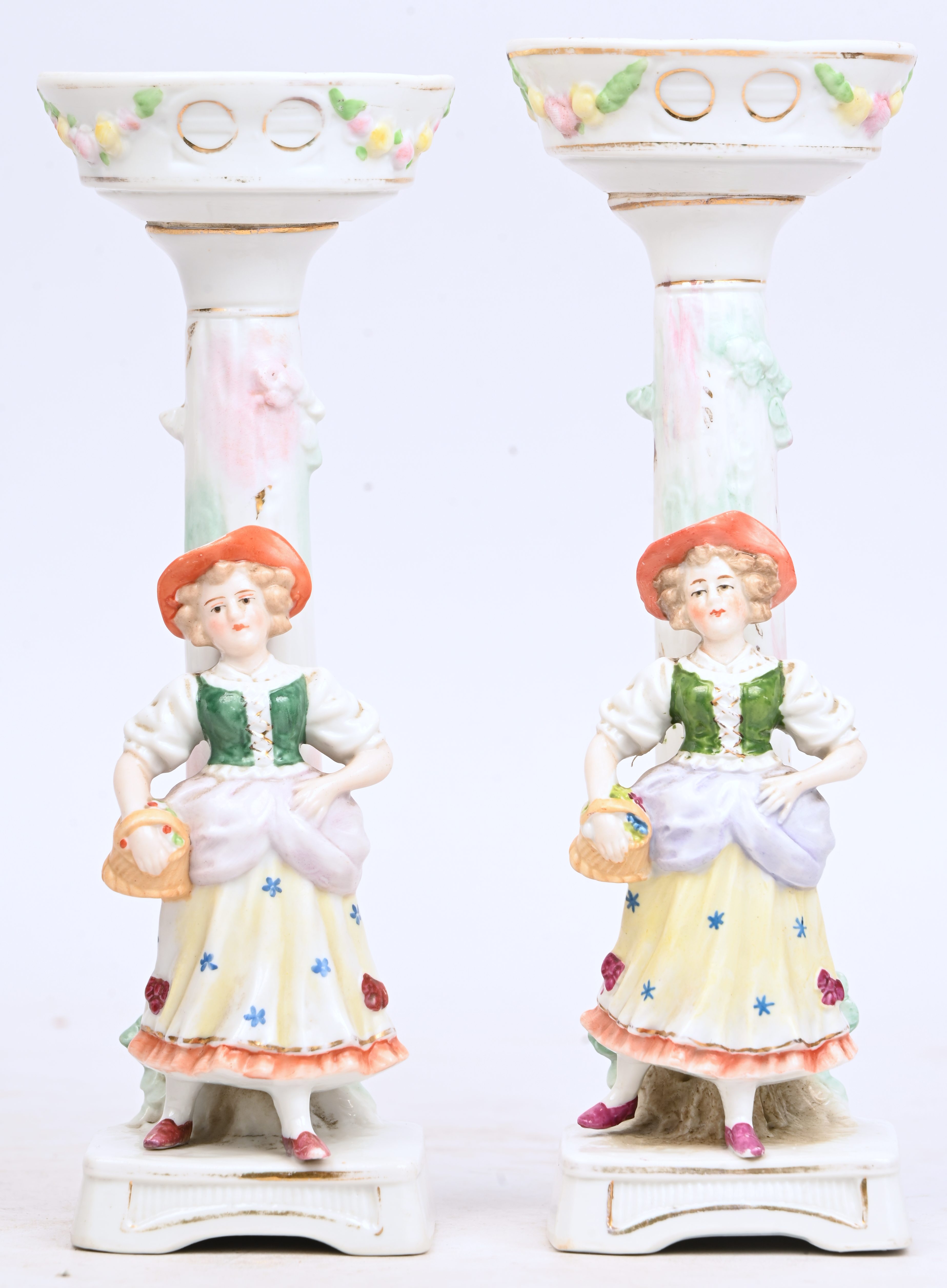 Twee porseleinen kandelaars met een bloemenmeisje Twee porseleinen kandelaars met een bloemenmeisje.