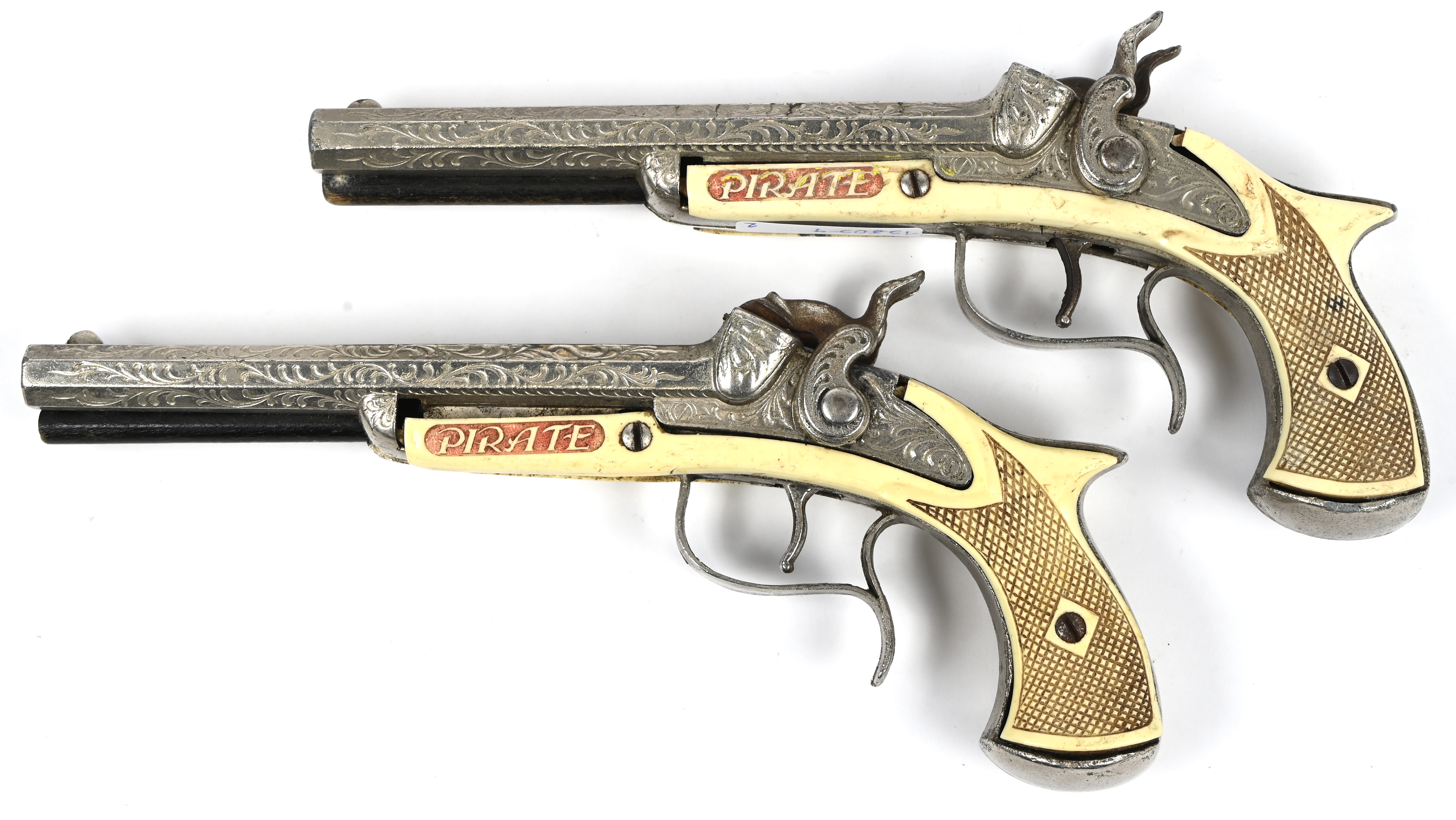 ‘Pirate’. Set van 2 vintage speelgoedpistolen. Jaren 60. 1 heeft ruime schade, het ander pistool is in goede staat ‘Pirate’. Set van 2 vintage speelgoedpistolen. Jaren 60. 1 heeft ruime schade, het ander pistool is in goede staat.