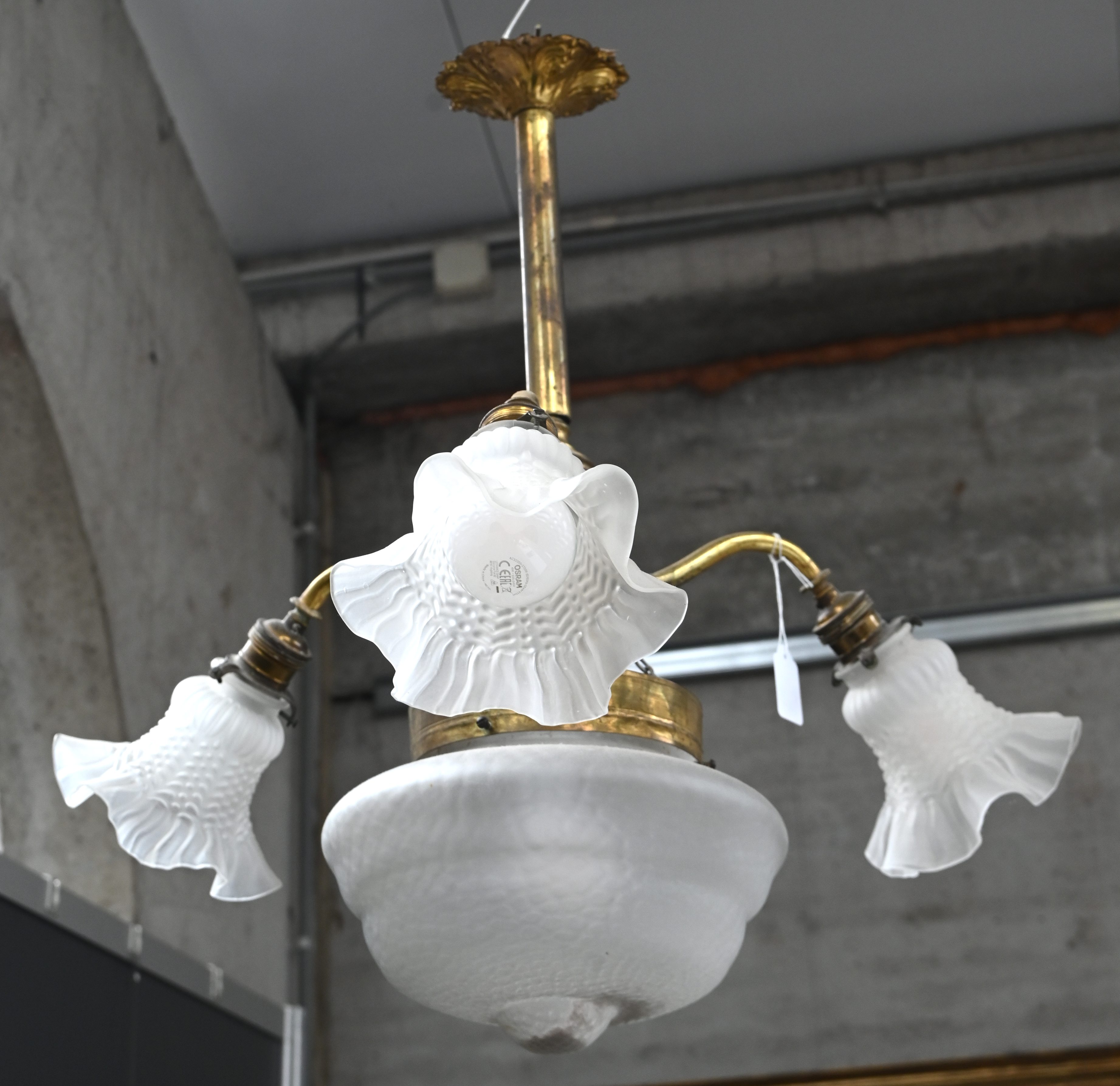 Een luchter, messing en glas met bloemvormige glazen blakers Een luchter, messing en glas met bloemvormige glazen blakers.