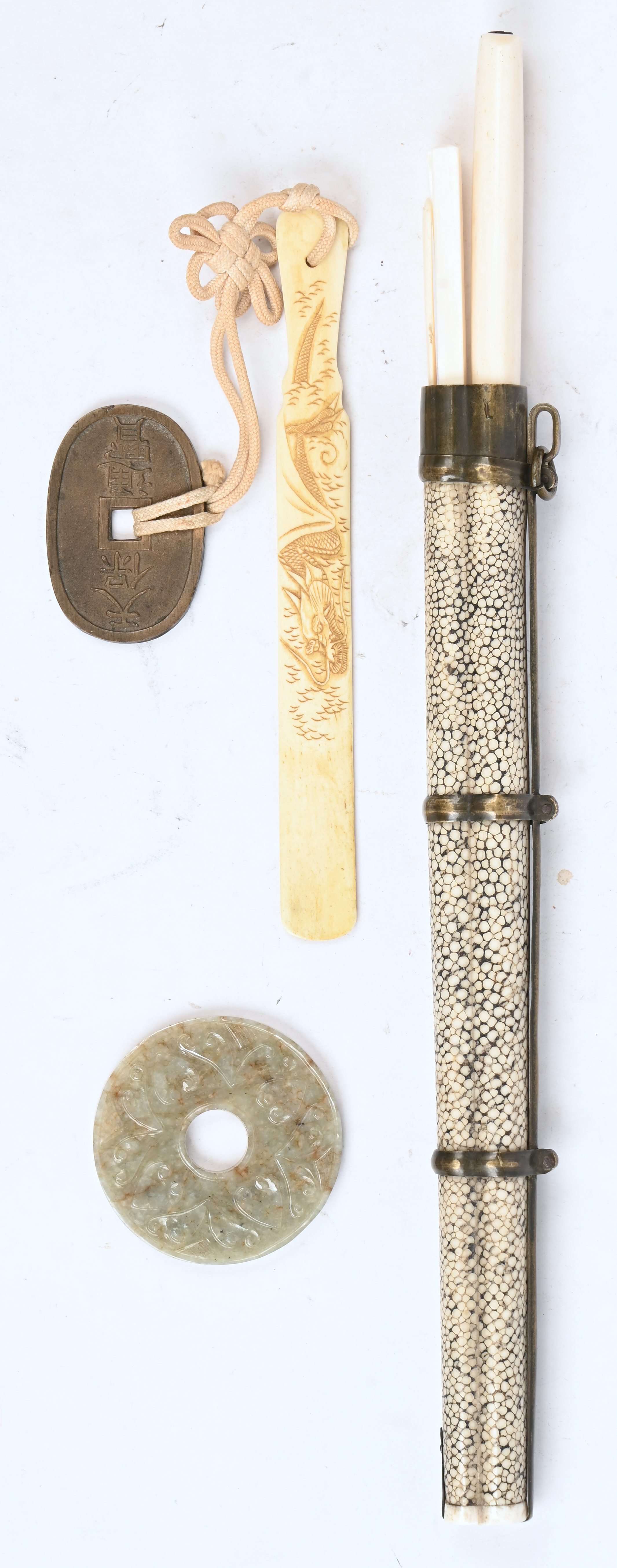 Een lot Chinese voorwerpen bestaande uit 4 spekstenen stempels, een benen briefopener, een benen set met chopsticks en mes in houder en een jade bi-schijf Een lot Chinese voorwerpen bestaande uit 4 spekstenen stempels, een benen briefopener, een benen set met chopsticks en mes in houder en een jade bi-schijf.