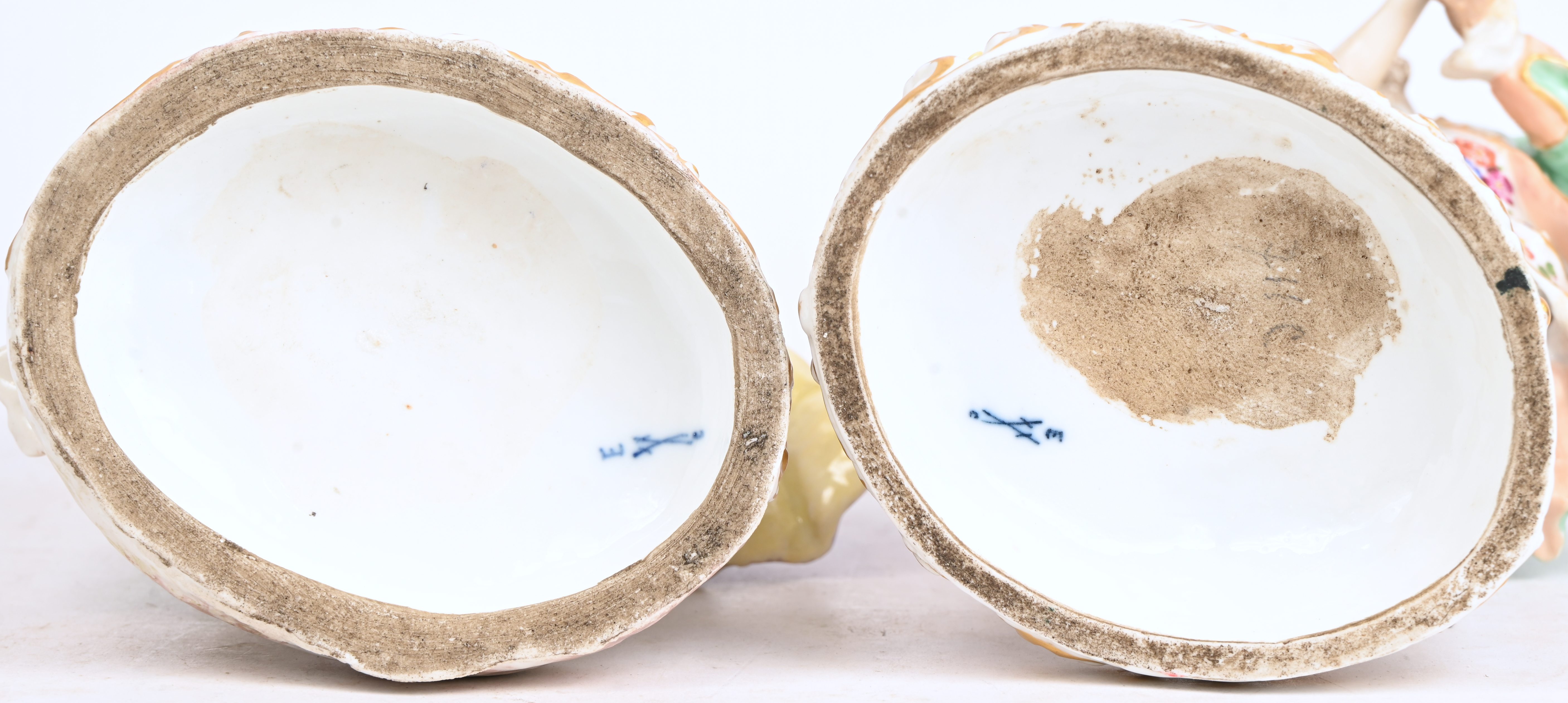 ‘Dansende koppeltjes’, twee groepjes van meerkleurig porselein met Meissen merk. Van één beeld zijn meerdere vingers manco ‘Dansende koppeltjes’, twee groepjes van meerkleurig porselein met Meissen merk. Van één beeld zijn meerdere vingers manco.