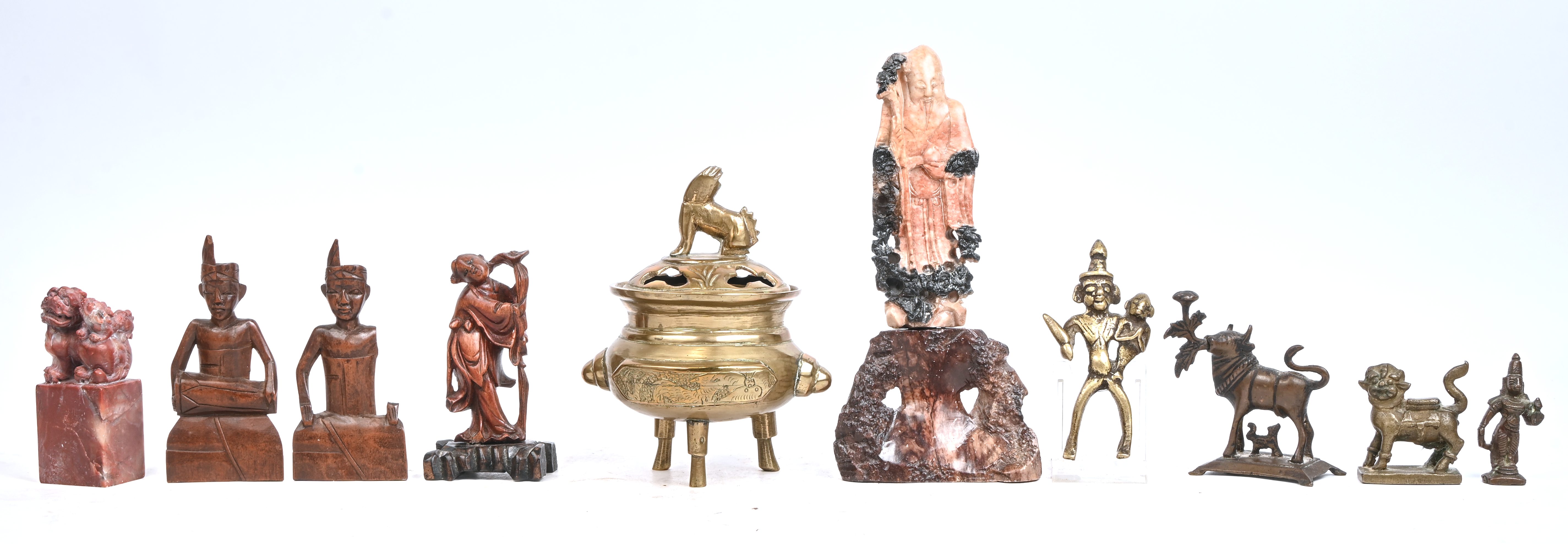 Een gevarieerd lot Aziatica bestaande uit 2 spekstenen beeldjes, 3 houten beeldjes, 4 beeldjes in koper en brons en een messing wierrookpotje met deksel Een gevarieerd lot Aziatica bestaande uit 2 spekstenen beeldjes, 3 houten beeldjes, 4 beeldjes in koper en brons en een messing wierrookpotje met deksel.