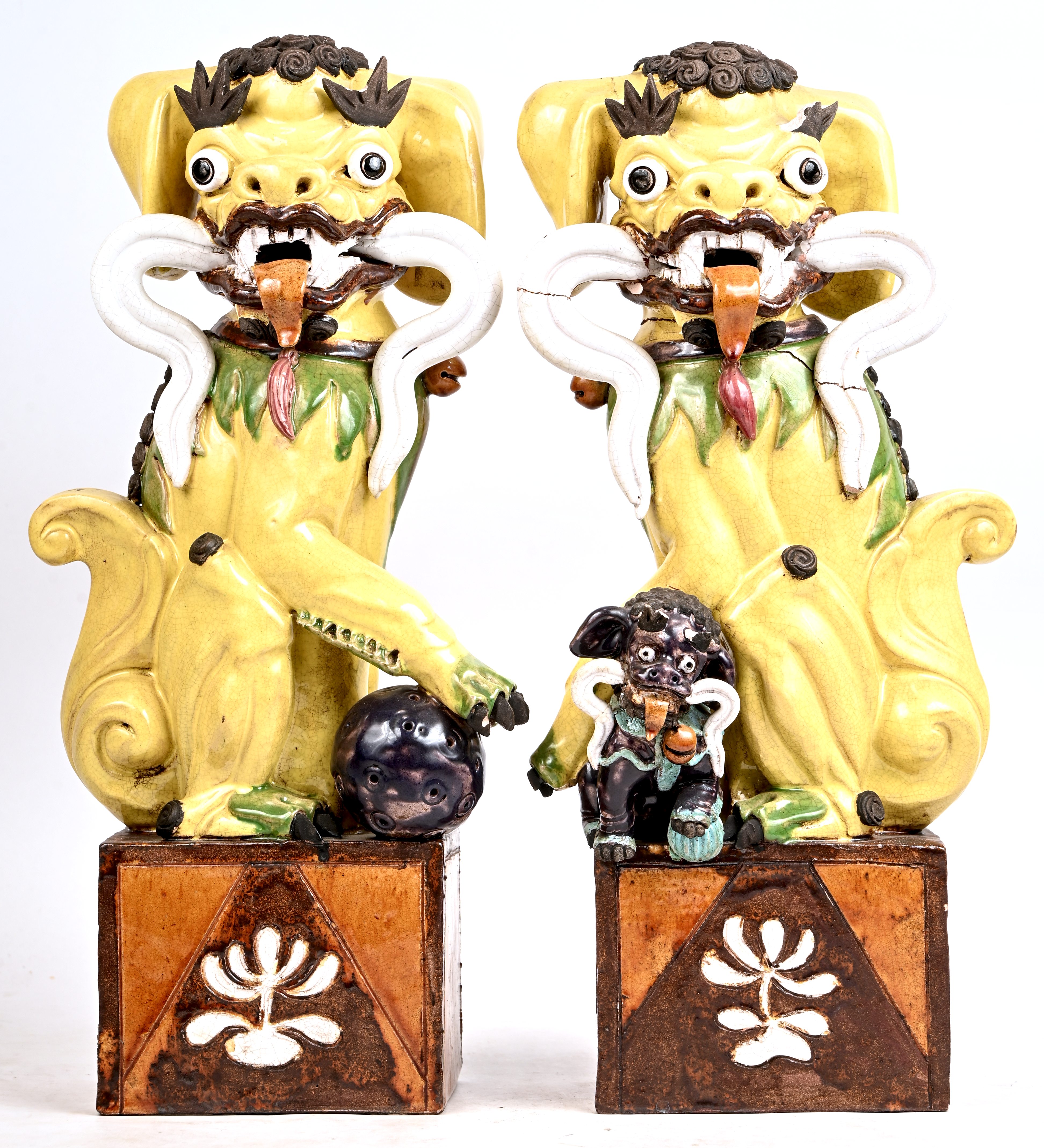Een set polychroom geglazuurde Foo dogs op sokkel gezeten. Eén met kleine schade, de andere op meerdere plaatsen gelijmd Een set polychroom geglazuurde Foo dogs op sokkel gezeten. Eén met kleine schade, de andere op meerdere plaatsen gelijmd.