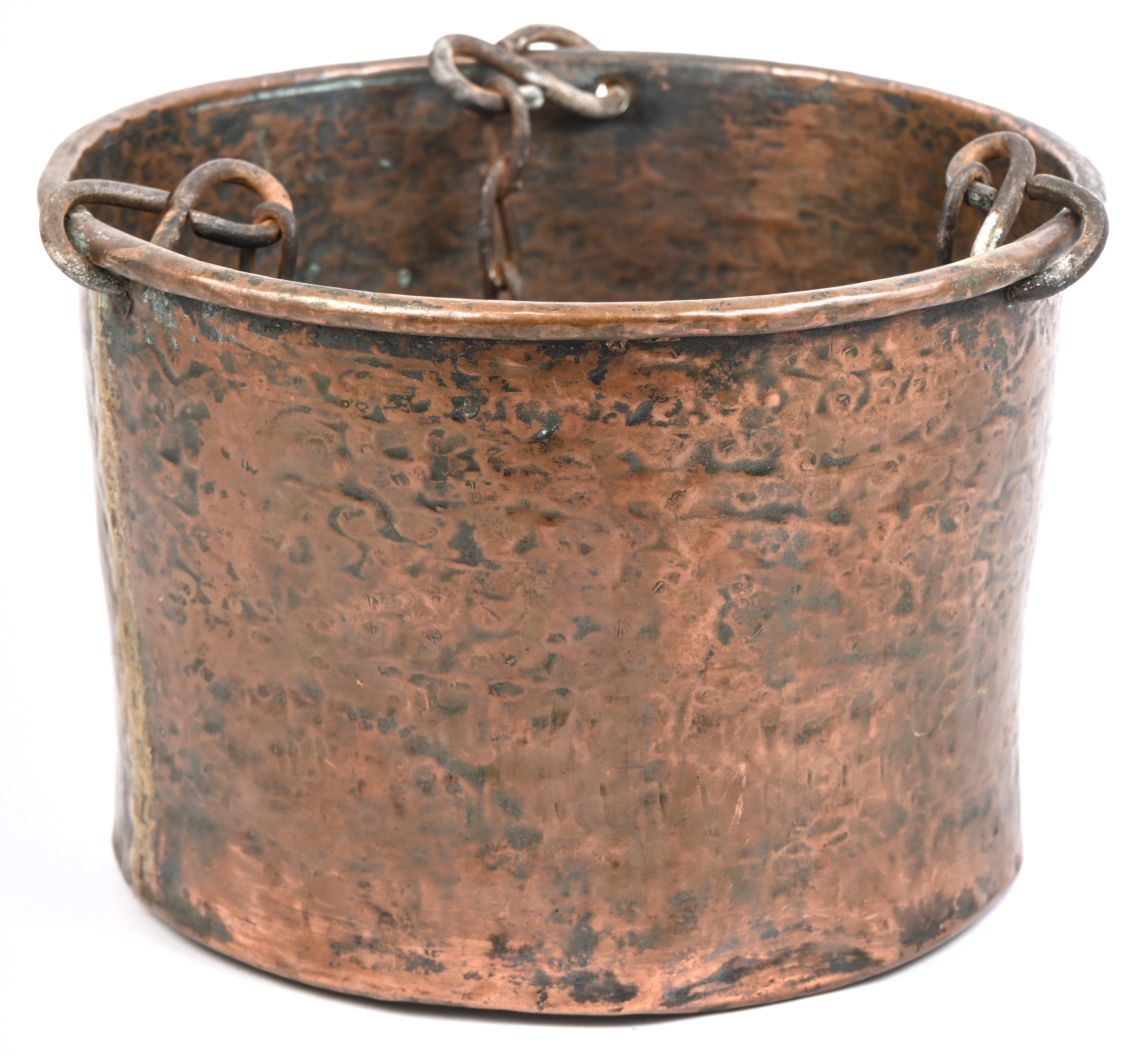Een oude rood koperen kookpot aan kettingen, voor in de open haard of boven open vuur Een oude rood koperen kookpot aan kettingen, voor in de open haard of boven open vuur.