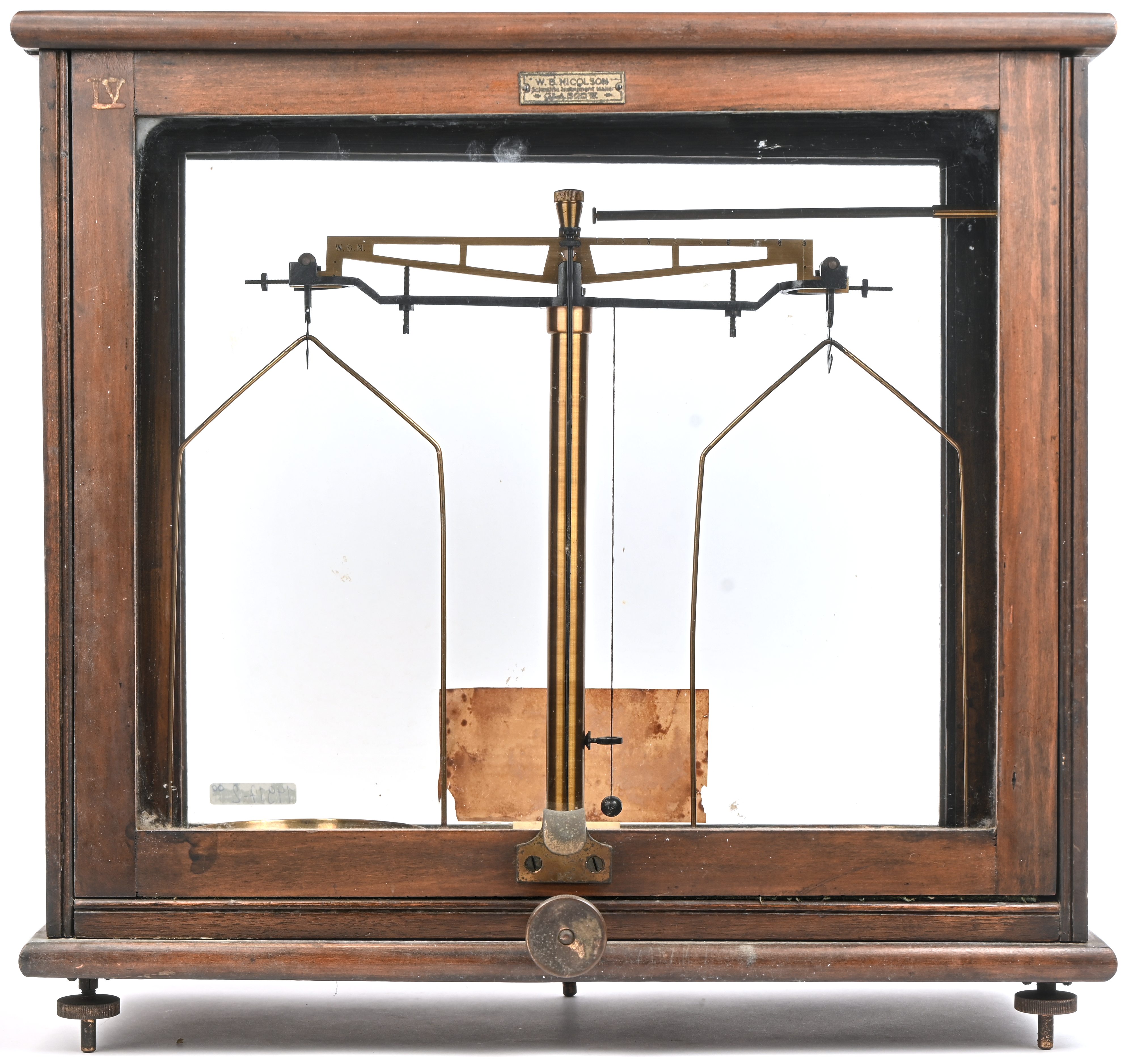 Een oude apothekersweegschaal in vitrine, gemerkt W.B. Nicolson, Glasgow Een oude apothekersweegschaal in vitrine, gemerkt W.B. Nicolson, Glasgow.