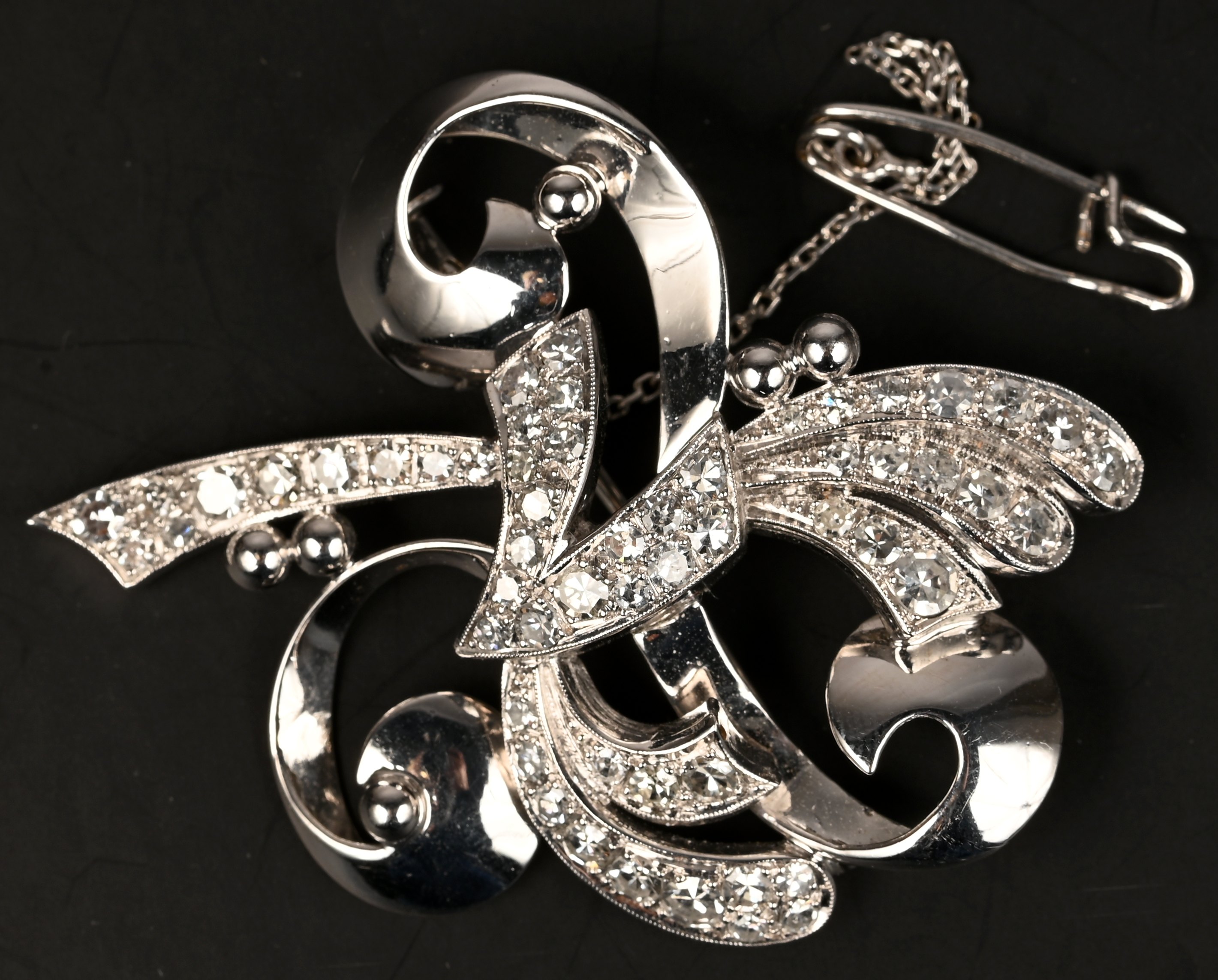 Een 18 kt platina broche bezet met briljanten met een gezamenlijk gewicht van +- 1 ct Een 18 kt platina broche bezet met briljanten met een gezamenlijk gewicht van +- 1 ct.