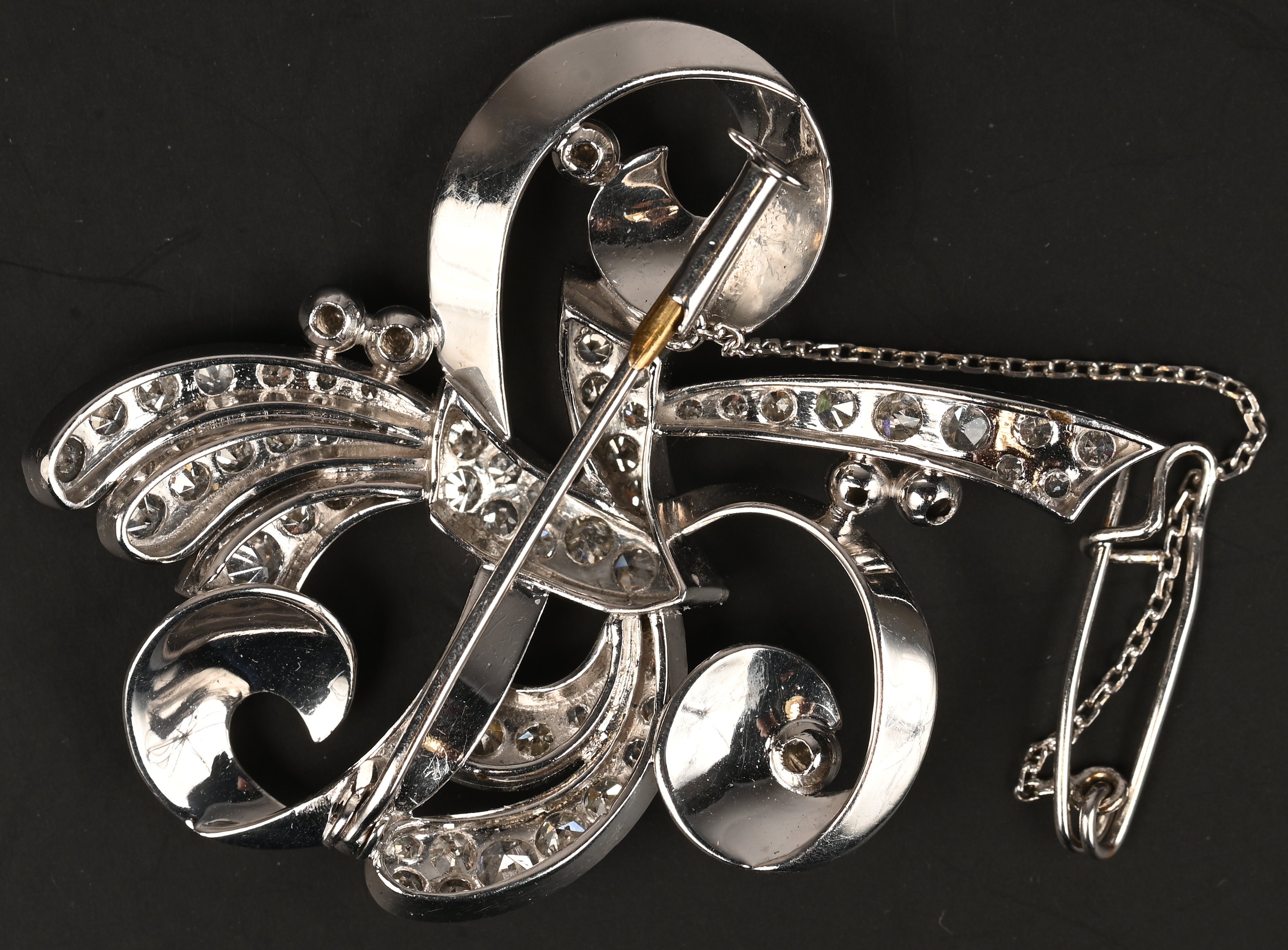 Een 18 kt platina broche bezet met briljanten met een gezamenlijk gewicht van +- 1 ct Een 18 kt platina broche bezet met briljanten met een gezamenlijk gewicht van +- 1 ct.