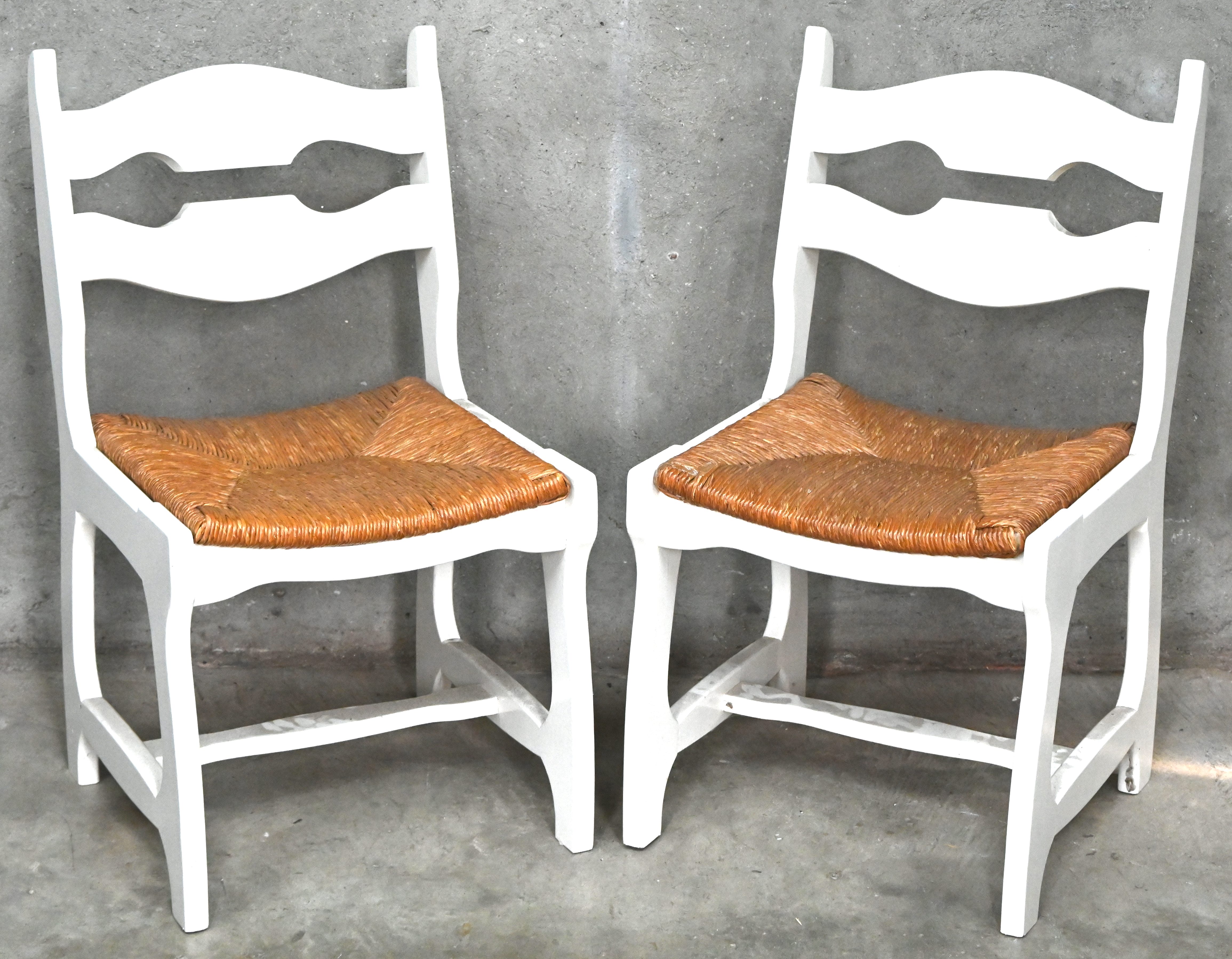Twee eikenhouten stoelen, vermoedelijk Guillerme et Chambron model Razor Back, met biezen zitting Twee eikenhouten stoelen, vermoedelijk Guillerme et Chambron model Razor Back, met biezen zitting.