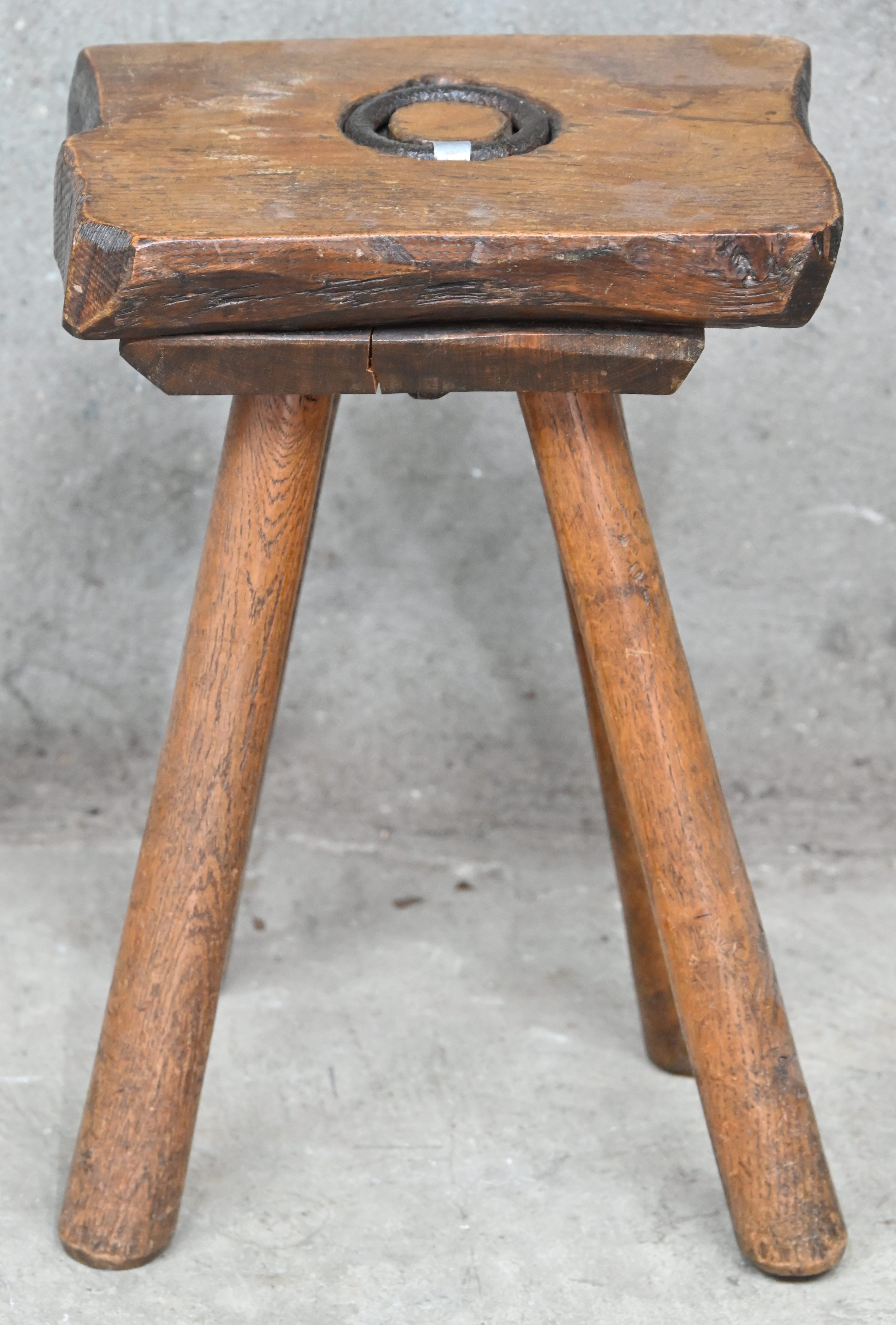 Een antiek eikenhouten melkkrukje met centrale ring Een antiek eikenhouten melkkrukje met centrale ring.