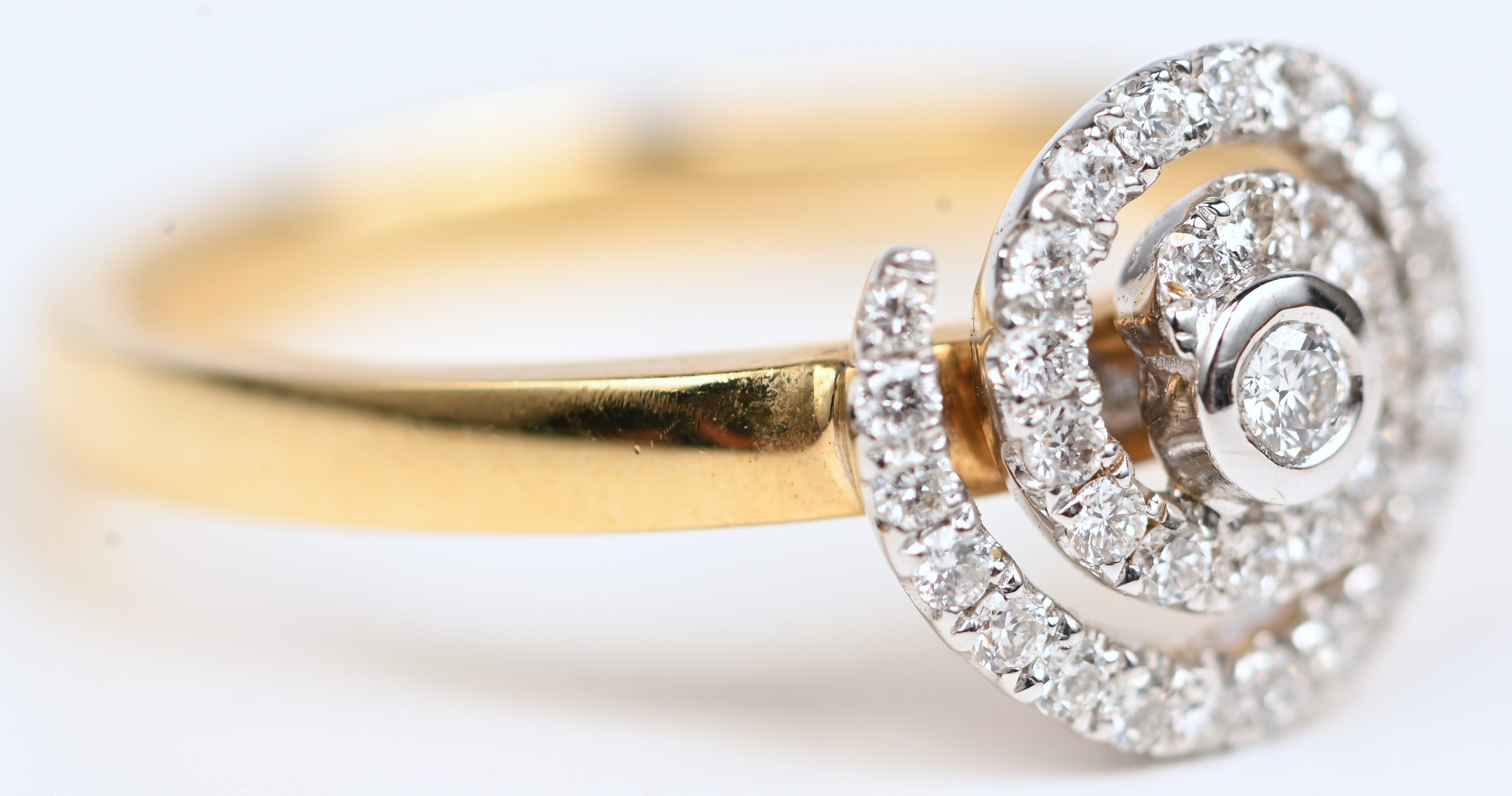 Een 18 kt wit- en geelgouden ring bezet met briljanten met een gezamenlijk gewicht van +- 0,32 ct Een 18 kt wit- en geelgouden ring bezet met briljanten met een gezamenlijk gewicht van +- 0,32 ct.