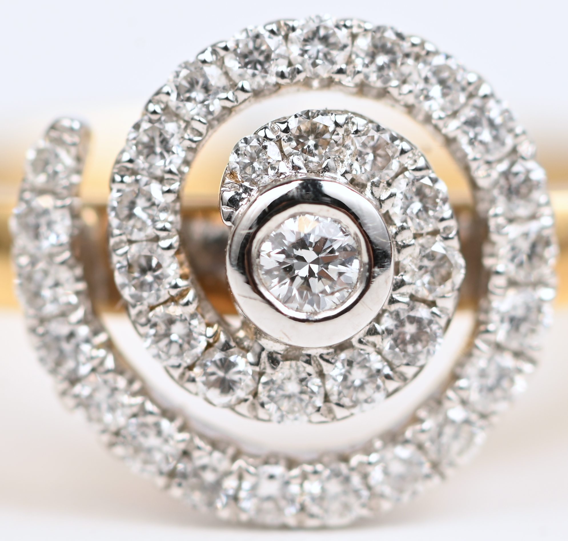 Een 18 kt wit- en geelgouden ring bezet met briljanten met een gezamenlijk gewicht van +- 0,32 ct Een 18 kt wit- en geelgouden ring bezet met briljanten met een gezamenlijk gewicht van +- 0,32 ct.