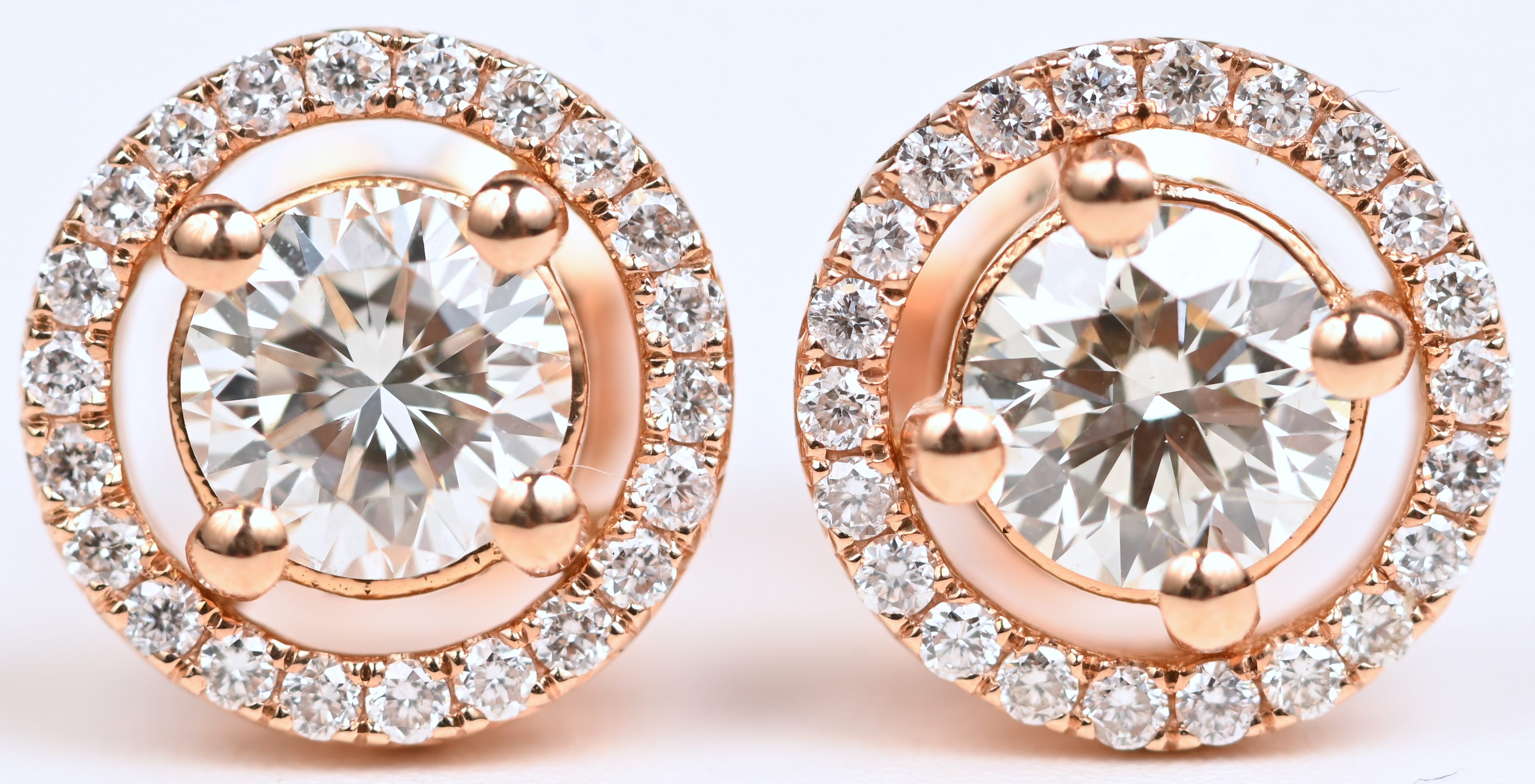 Een paar 18 kt roosgouden oorbellen bezet met centrale briljant 1,08 ct. totaal. HVS1 En briljanten met een gezamenlijk gewicht van 0,28 ct totaal. FVS1 Een paar 18 kt roosgouden oorbellen bezet met centrale briljant 1,08 ct. totaal. HVS1 En briljanten met een gezamenlijk gewicht van 0,28 ct totaal. FVS1.