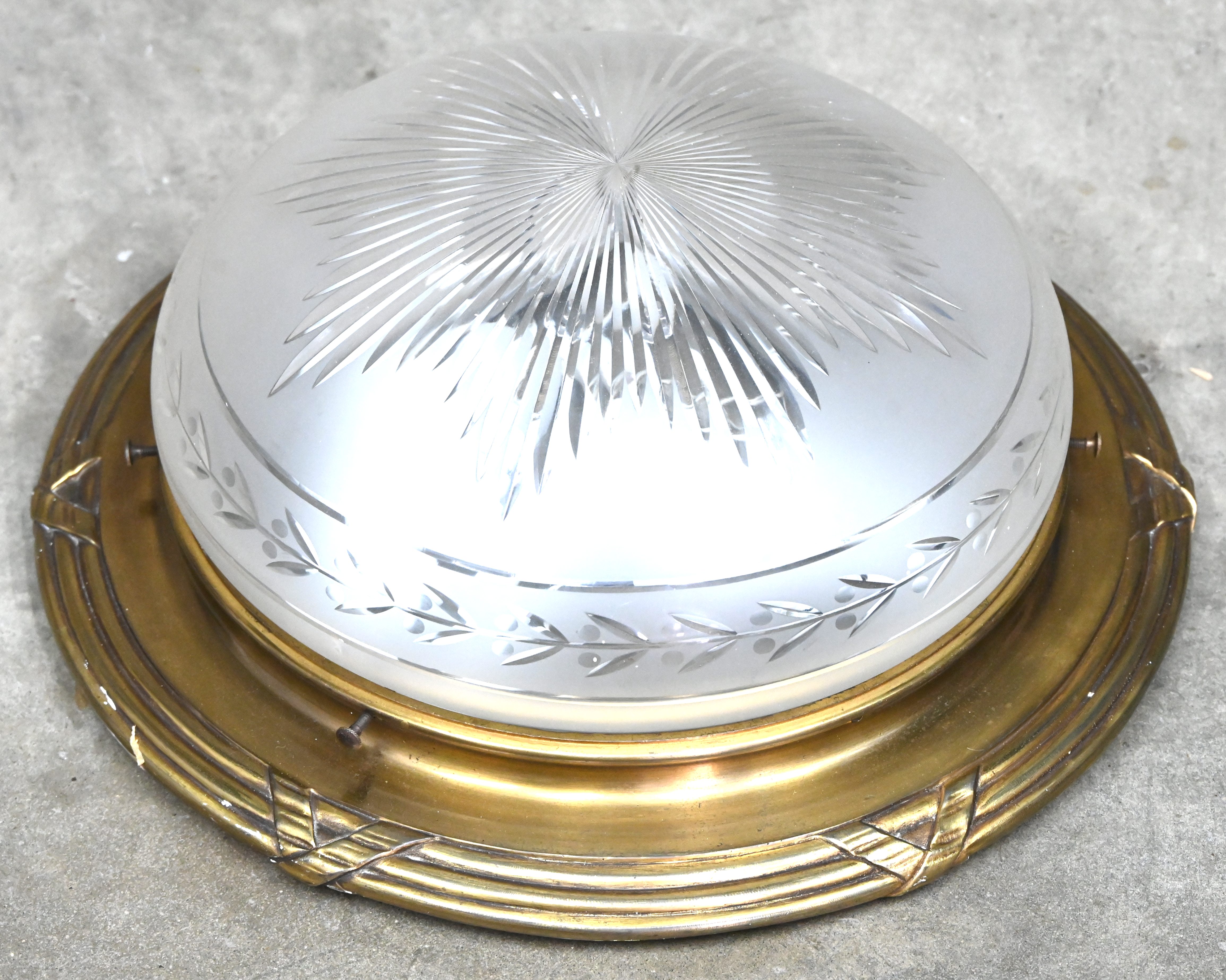 Een plafoniere van brons met een centrale coupe van geslepen glas Een plafoniere van brons met een centrale coupe van geslepen glas.