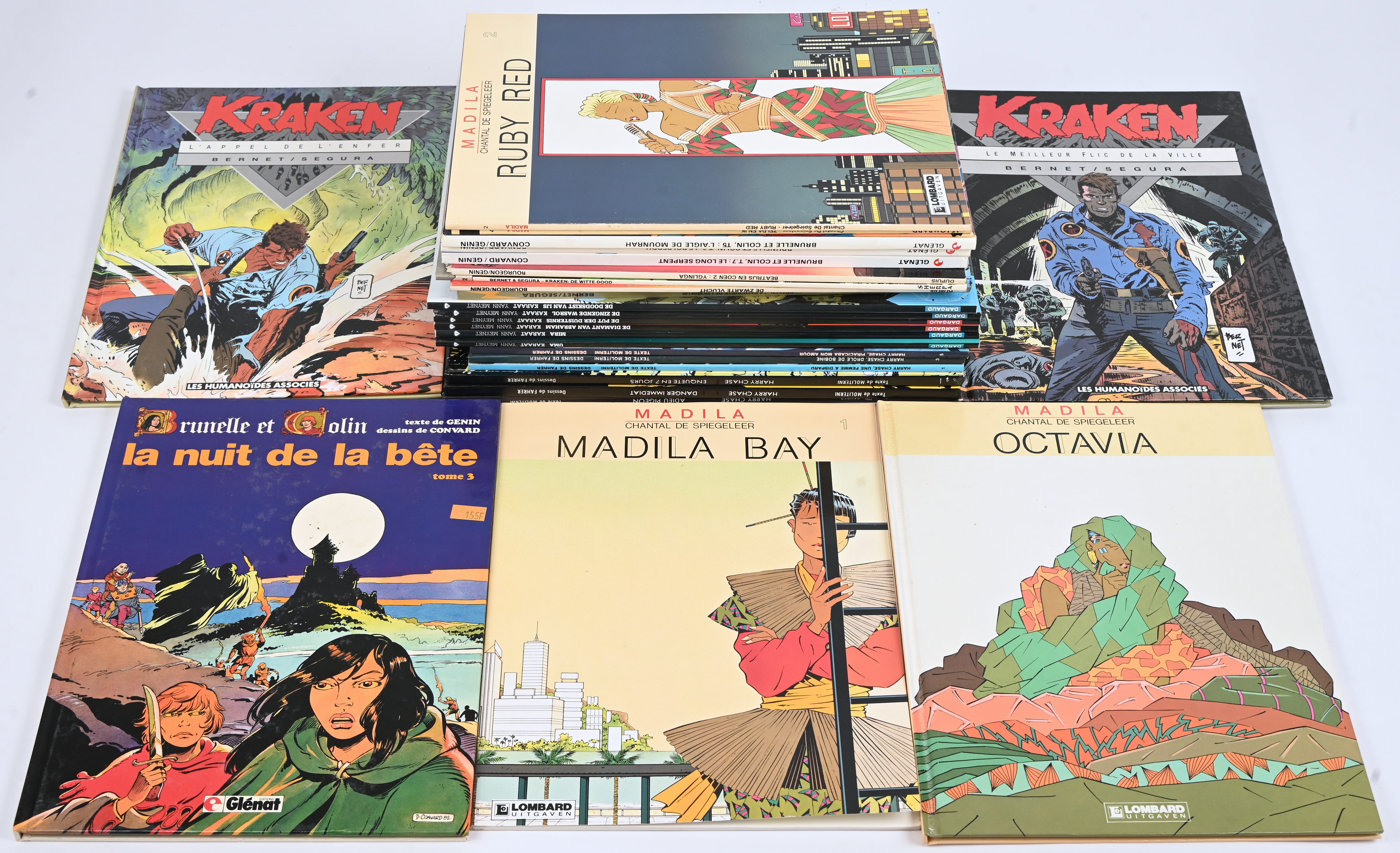 Een partij stripalbums met titels uit de reeksen: ‘Kraken’ (4 waarvan 3 Franstalige hardcovers), ‘Karaat’ (6), ‘Harry Chase’ (6 waarvan 3 hardcover, Franstalig), ‘Beatrijs en Koen’ (2), ‘Brunella et Colin’ (4 Franstalige hardcovers) en ‘Madila’ (4 waarvan 1 hardcover). Mogelijk met geschreven markeringen op de kaft Een partij stripalbums met titels uit de reeksen: ‘Kraken’ (4 waarvan 3 Franstalige hardcovers), ‘Karaat’ (6), ‘Harry Chase’ (6 waarvan 3 hardcover, Franstalig), ‘Beatrijs en Koen’ (2), ‘Brunella et Colin’ (4 Franstalige hardcovers) en ‘Madila’ (4 waarvan 1 hardcover). Mogelijk met geschreven markeringen op de kaft.